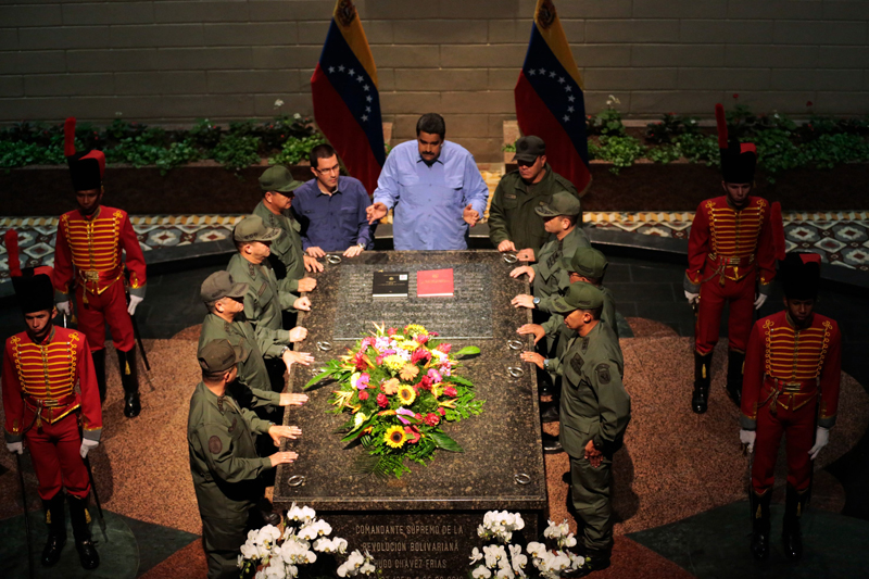 El presidente de Venezuela, Nicolás Maduro (centro), habla sobre la tumba del expresidente Hugo Chavez, en Caracas. El mandatario anunció que reestructurará su gabinete. | AFP