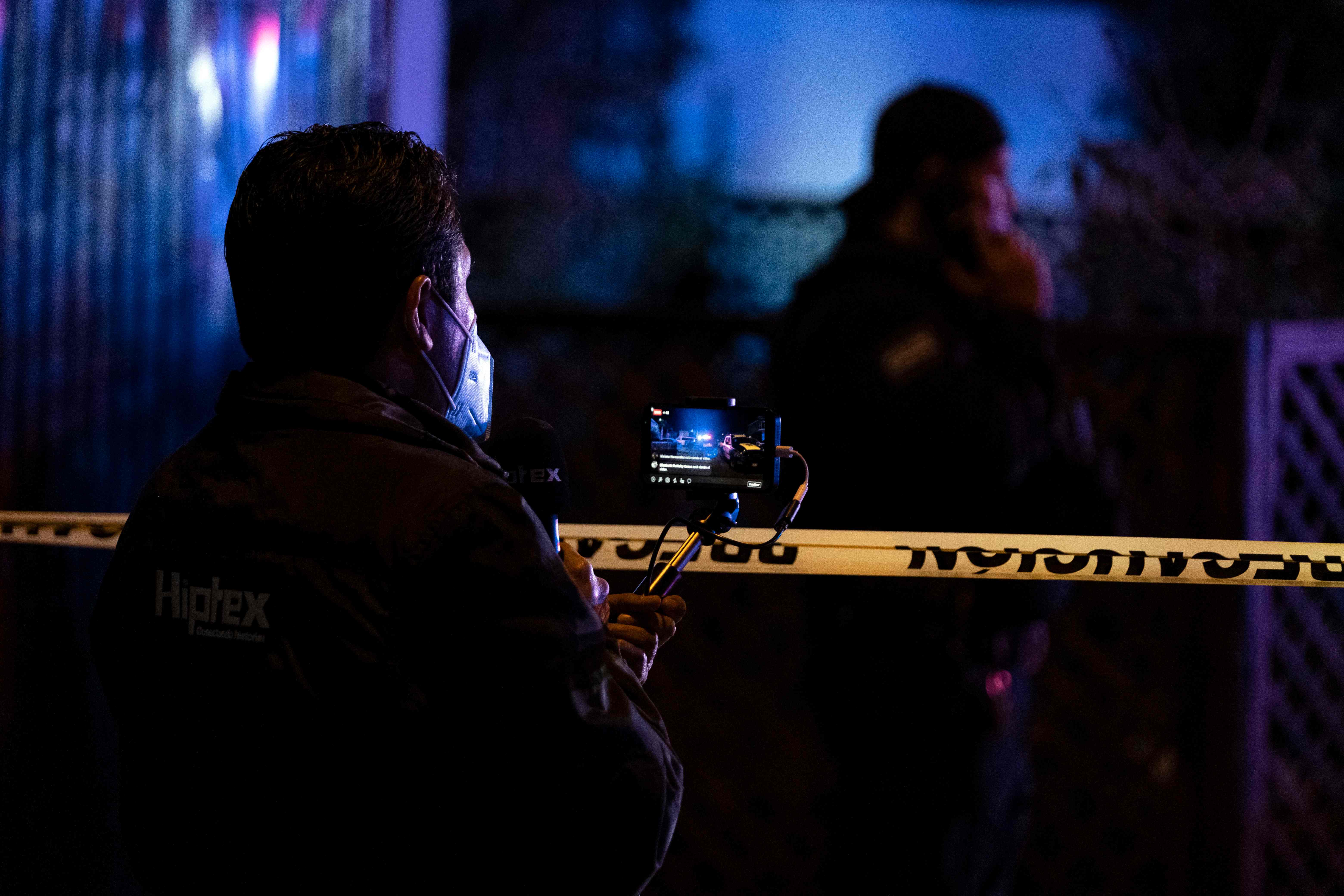 Journalists cover the crime scene where journalist Lourdes Maldonado was murdered in Santa Fe, Tijuana's outskirts, Baja California, Mexico, on January 23, 2022. - A journalist was killed in Tijuana January 23, 2022, the local prosecutor said, the second media worker murdered in less than a week in the Mexican city on the US border. (Photo by Guillermo Arias / AFP)
