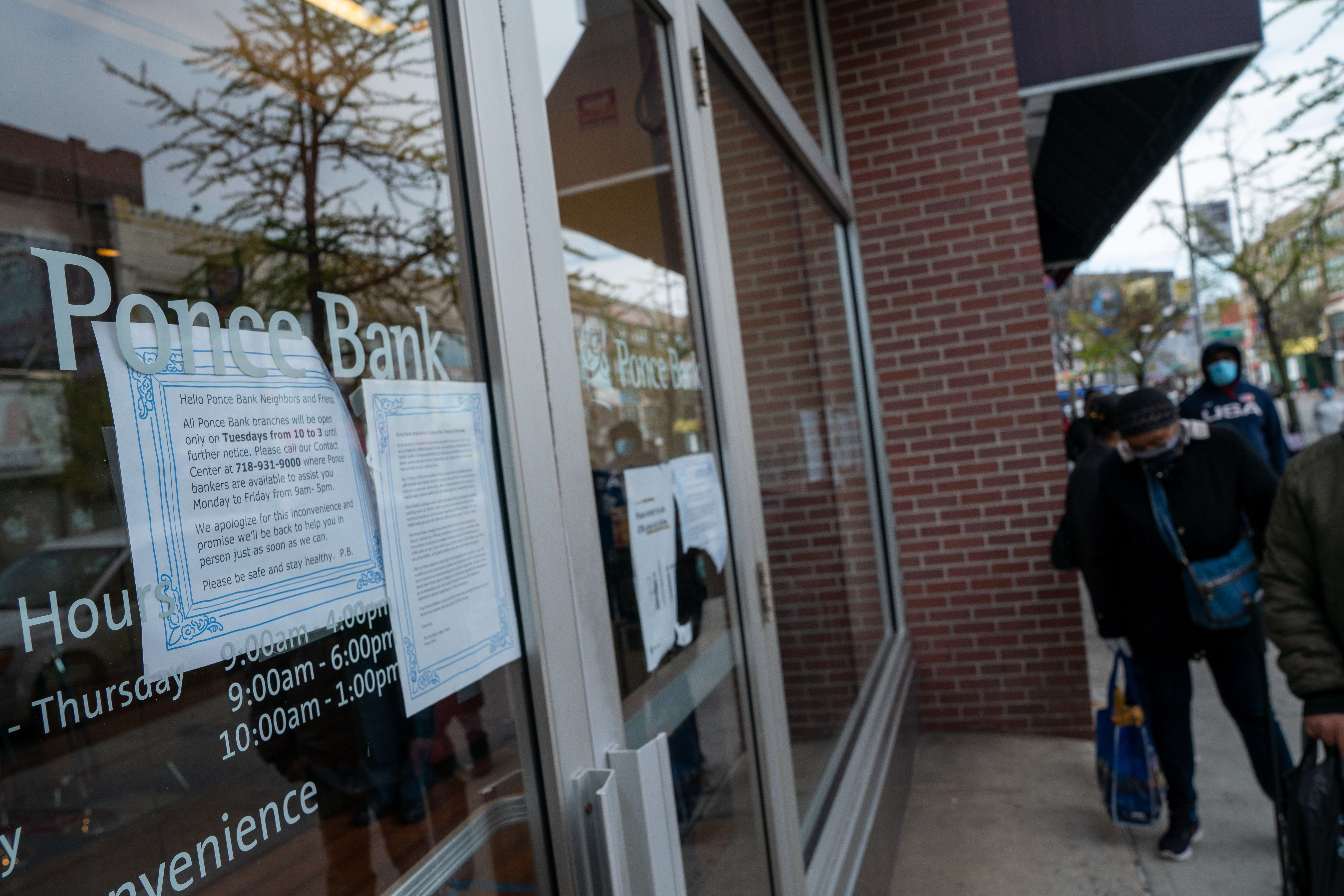 NEW YORK, NY - APRIL 14: A sign outside of Ponce Bank announces the bank's hours of operation on April 14, 2020 in the Bronx borough of New York City informs customers of tellers being available on one day of the week. The Ponce Bank located on Southern Boulevard is one of three branches in the Bronx borough that has tellers available for its customers open only on Tuesday's due to the COVID-19 pandemic. David Dee Delgado/Getty Images/AFP
== FOR NEWSPAPERS, INTERNET, TELCOS & TELEVISION USE ONLY ==