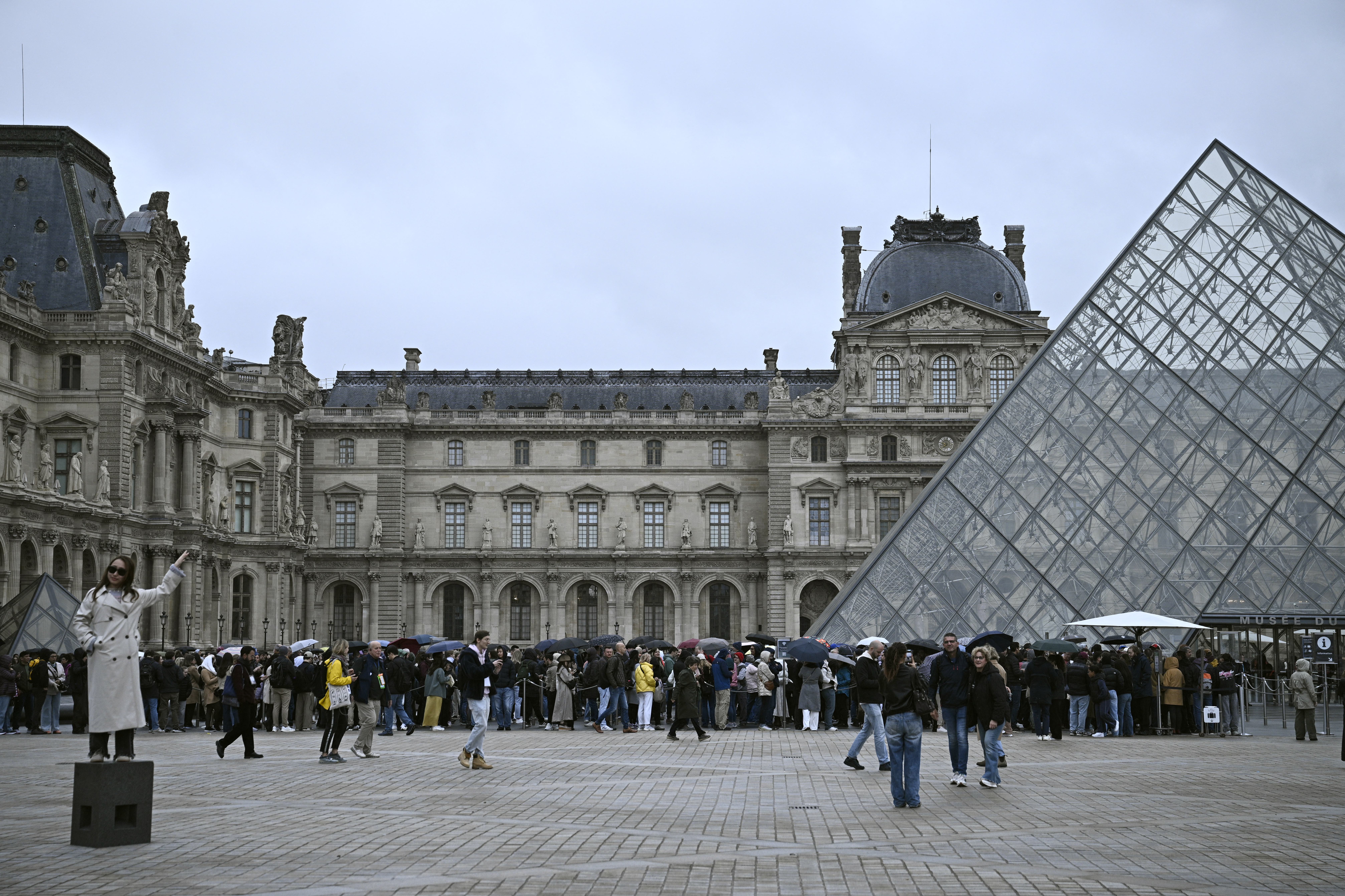 La gente hace cola en el patio de la pirámide del Louvre momentos antes del anuncio de que el museo permanecerá cerrado por segundo día consecutivo después de que los ladrones robaran las joyas de la corona del museo en París un día antes, en París el 20 de octubre de 2025.