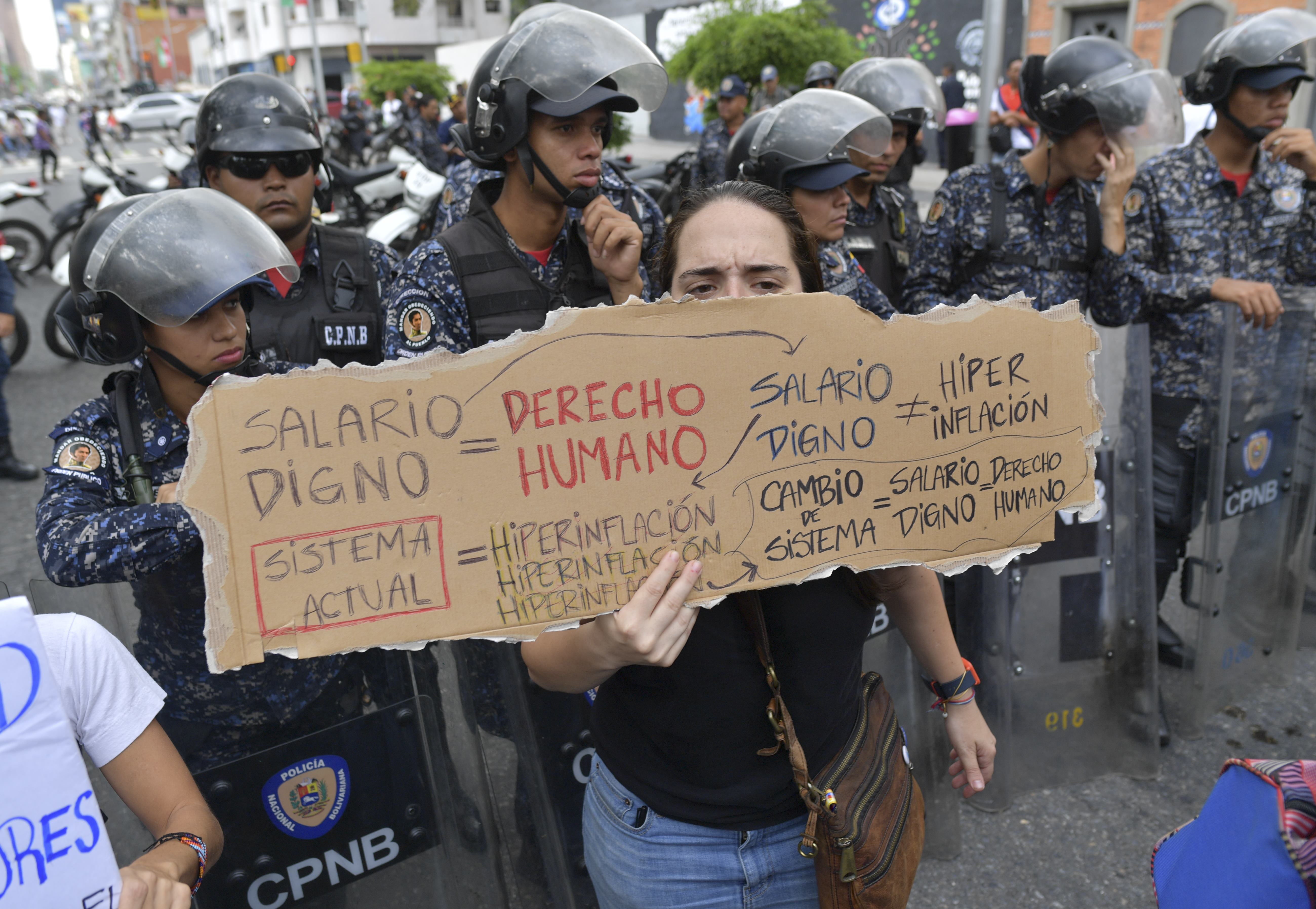 A state employee shouts slogans during a demonstration demanding the Venezuelan government for salary improvements as the police blocks their way in Caracas, on November 28, 2018. - Venezuela is in the midst of an economic meltdown triggered by mismanagement and a slump in oil prices followed by US sanctions. (Photo by Yuri CORTEZ / AFP)