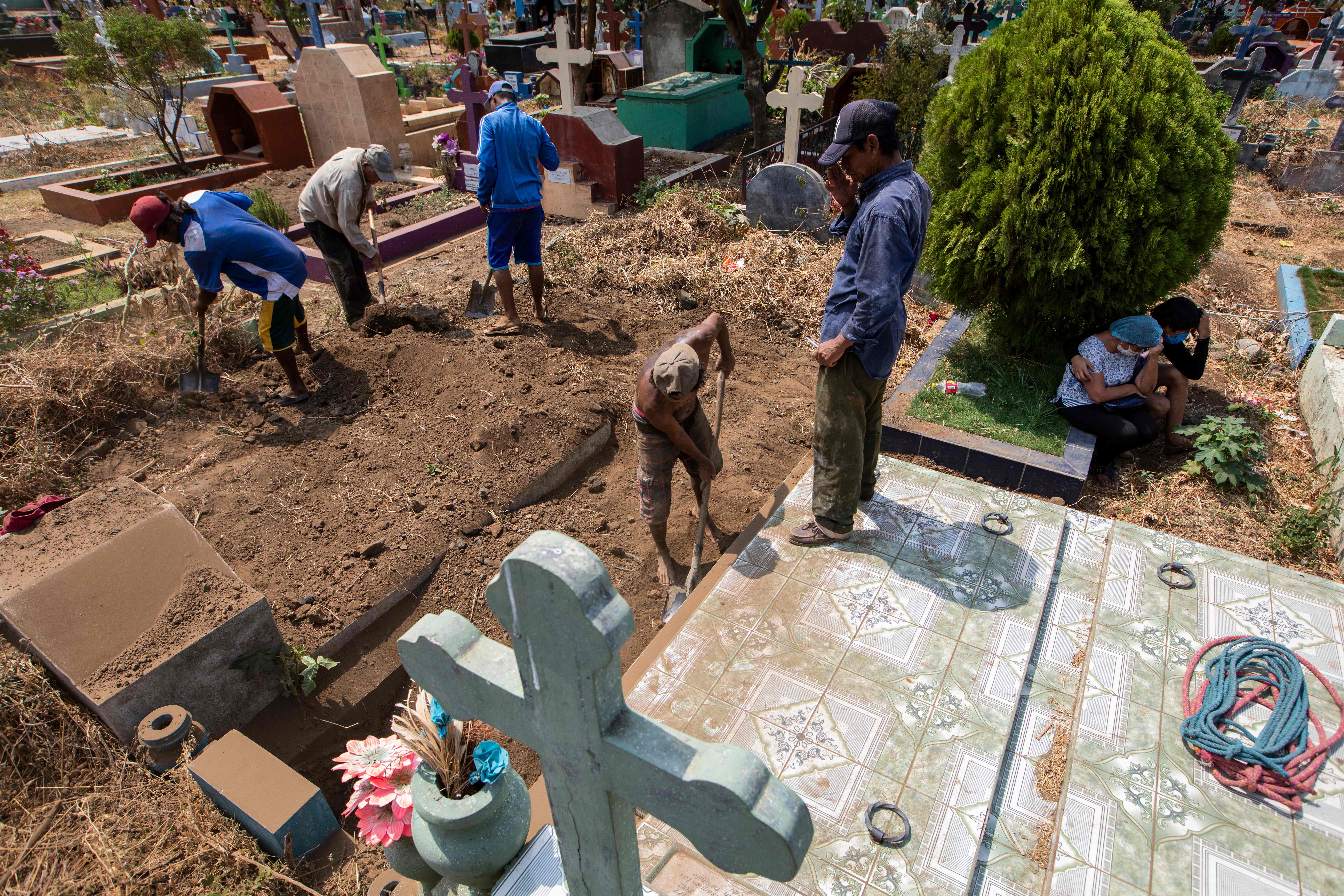 Gravediggers bury the coffin of a mechanic called Roberto, who died at a hospital with symptoms of the novel coronavirus, COVID-19 and did not have a wake before his burial, during the funeral at the Milagro de Dios Cemetery in Managua, on May 9, 2020. - The novel coronavirus has killed at least 276,435 people worldwide since the outbreak first emerged in China last December, according to a tally from official sources compiled by AFP at 1900 GMT on Saturday (Photo by Inti OCON / AFP)