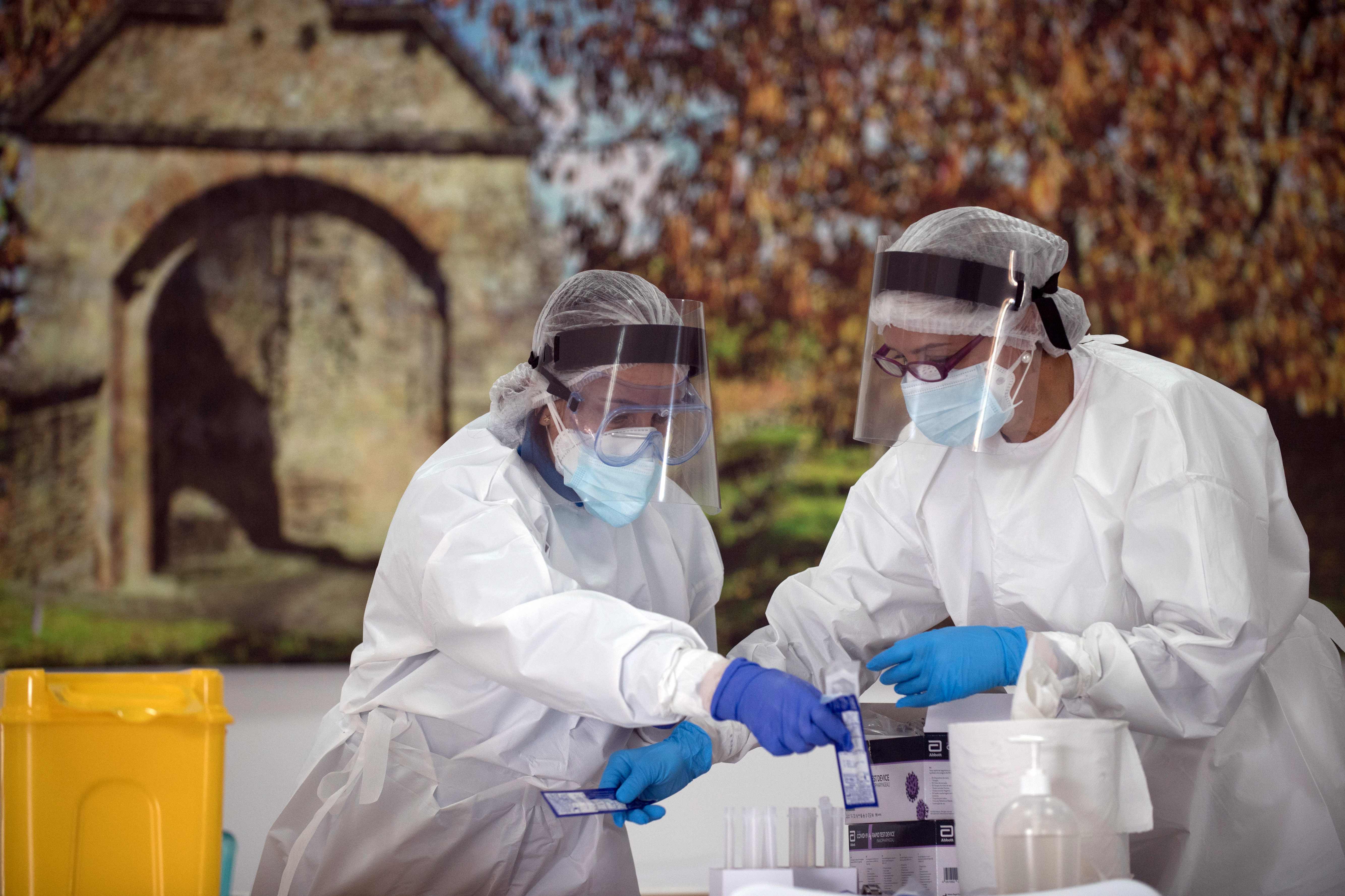 Healthcare workers handle swabs during a mass testing for COVID-19 at a temporary testing centre in Ronda, on November 11, 2020. - Spain's death toll surged over 40,000 today with infections passing the 1.4 million mark, while the rate of new cases continued to grow, health ministry data showed. The virus has now claimed 40,105 lives in Spain, which has the fourth-highest death rate within the European Union after the United Kingdom, France and Italy. (Photo by JORGE GUERRERO / AFP)