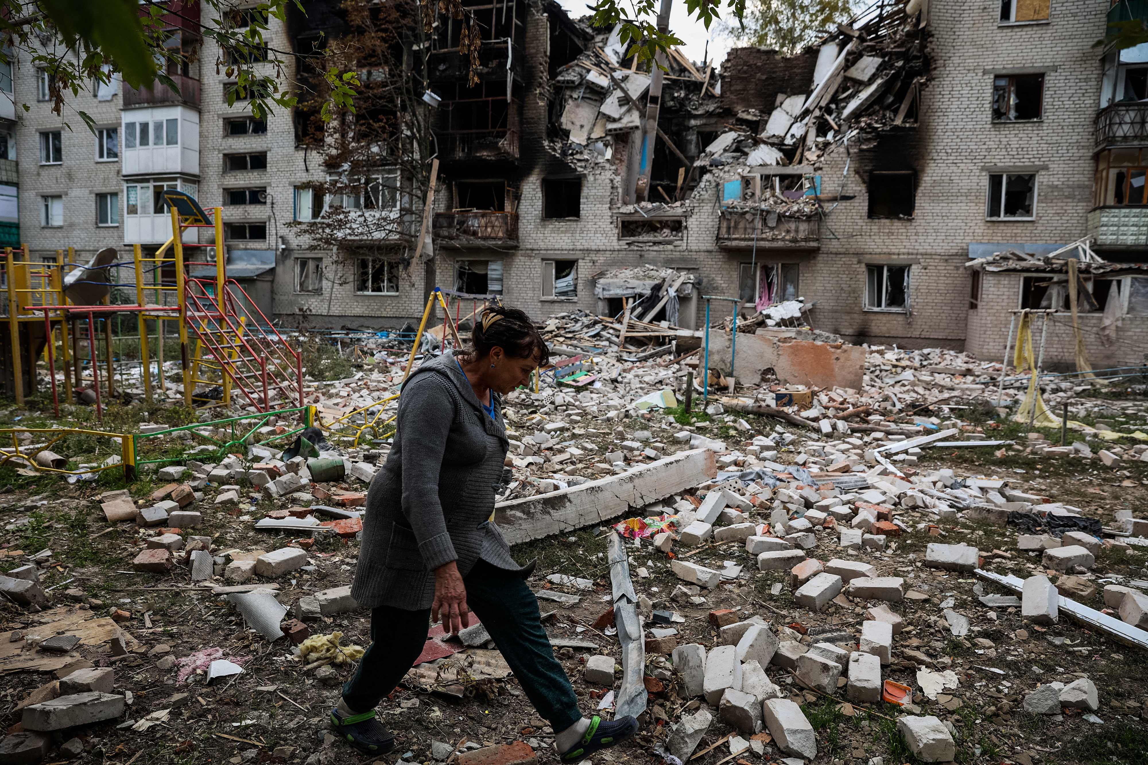 A pedestrian walks in a yard of a destroyed apartment building in the town of Sviatohirsk, Donetsk region, on September 30, 2022, amid the Russian invasion of Ukraine.
, (Photo by ANATOLII STEPANOV / AFP)