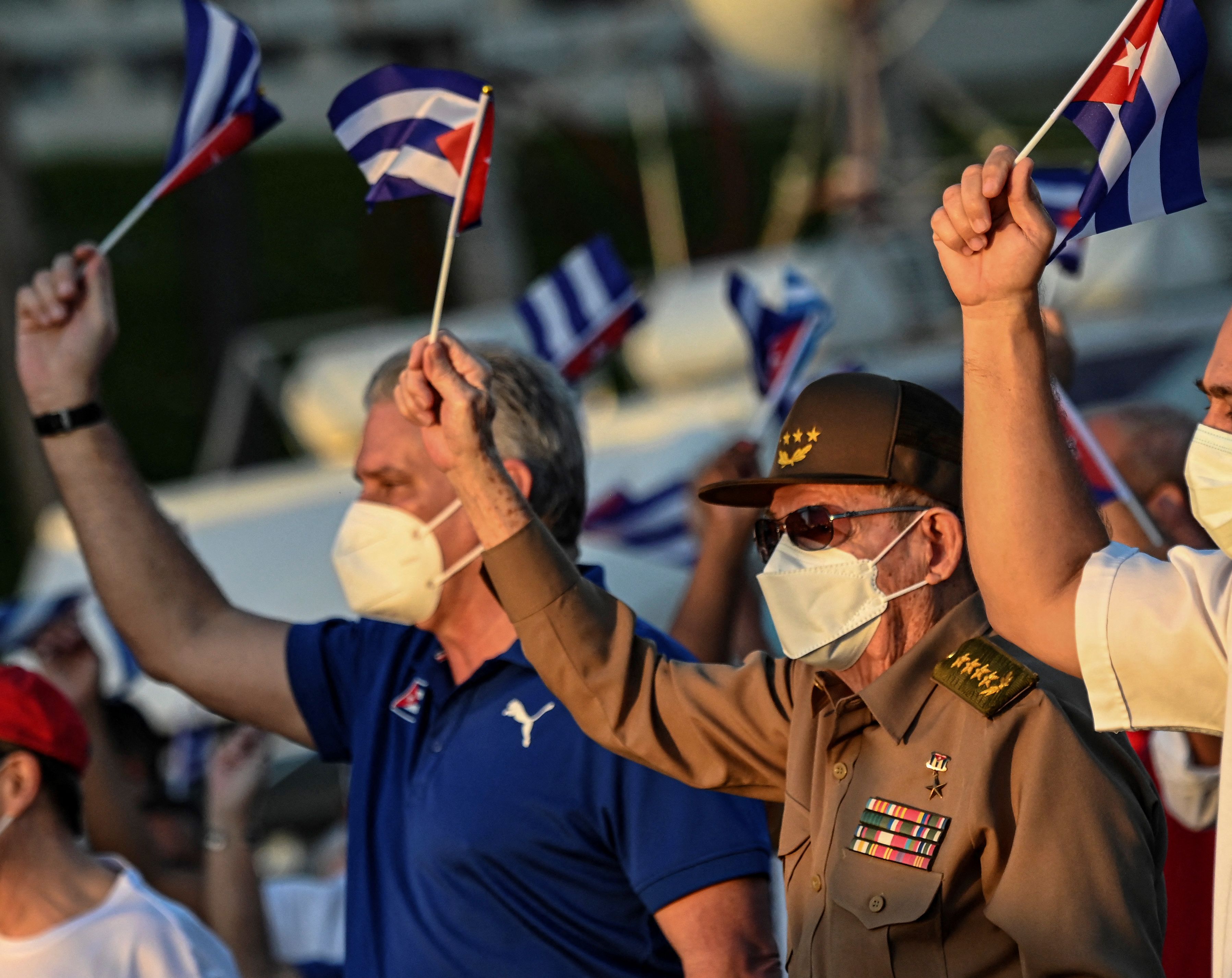 Cuban President Miguel Diaz-Canel (L) and former President Raul Castro (R) wave Cuban flags during an act of revolutionary reaffirmation in Havana, on July 17, 2021. (Photo by YAMIL LAGE / AFP)