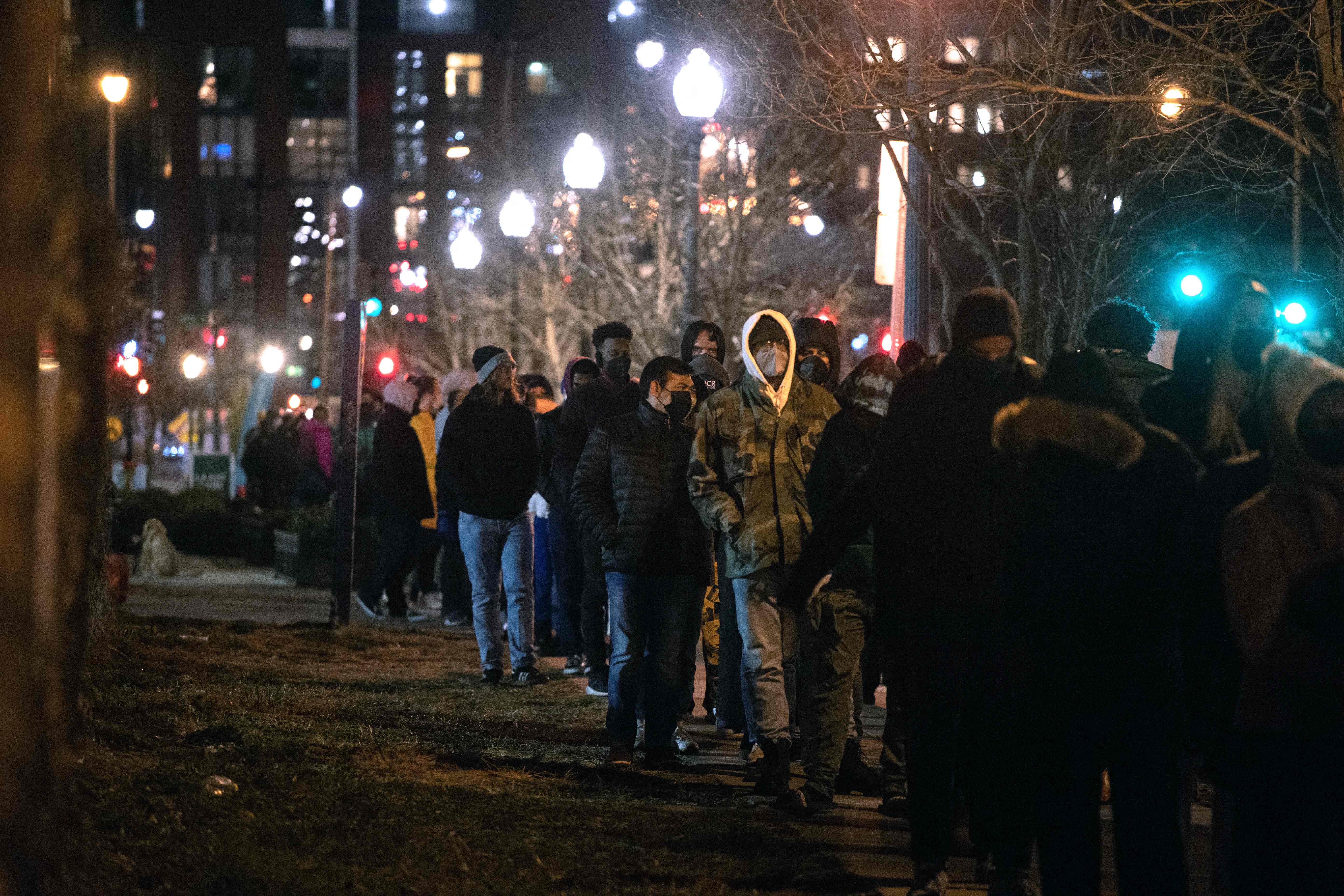 People line up to get tested for Covid-19 outside at a firehouse in Washington, DC on December 20, 2021. - The fast-spreading Omicron variant is now the main coronavirus strain in the United States, accounting for 73.2 percent of new cases over the past week for which data is available, health authorities reported December 20, 2021. (Photo by ROBERTO SCHMIDT / AFP)