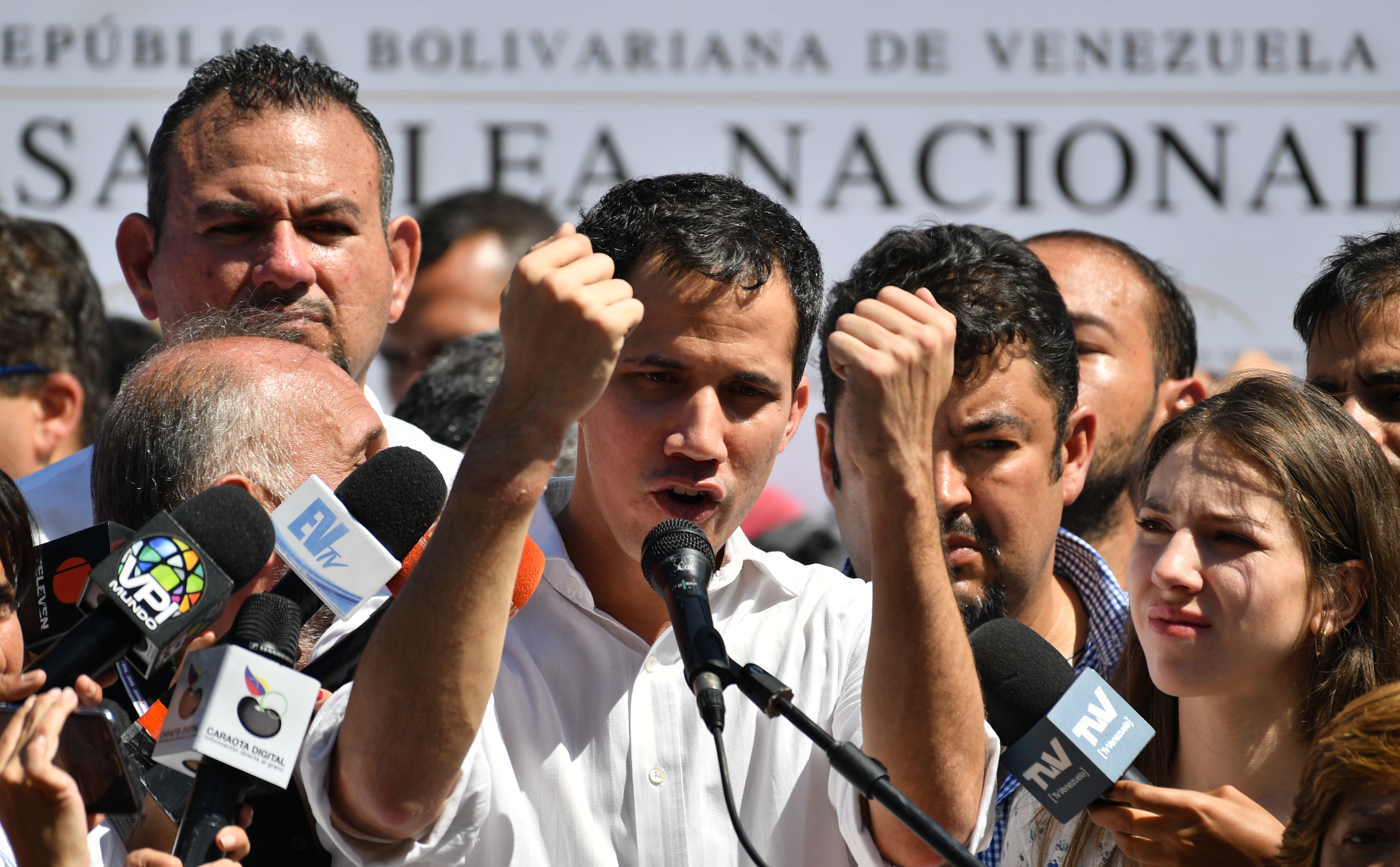 Venezuela's National Assembly president Juan Guaido gestures as he speaks before a crowd of opposition supporters during an open meeting in Vargas, Venezuela, on January 13, 2019. - The president of the opposition-controlled but sidelined National Assembly was released less than an hour after being arrested by Venezuelan intelligence agents on Sunday, his wife said. Guaido had directly challenged the legitimacy of Nicolas Maduro as the president was sworn in for a second term on Thursday, calling for a transitional government ahead of new elections. (Photo by Yuri CORTEZ / AFP)
