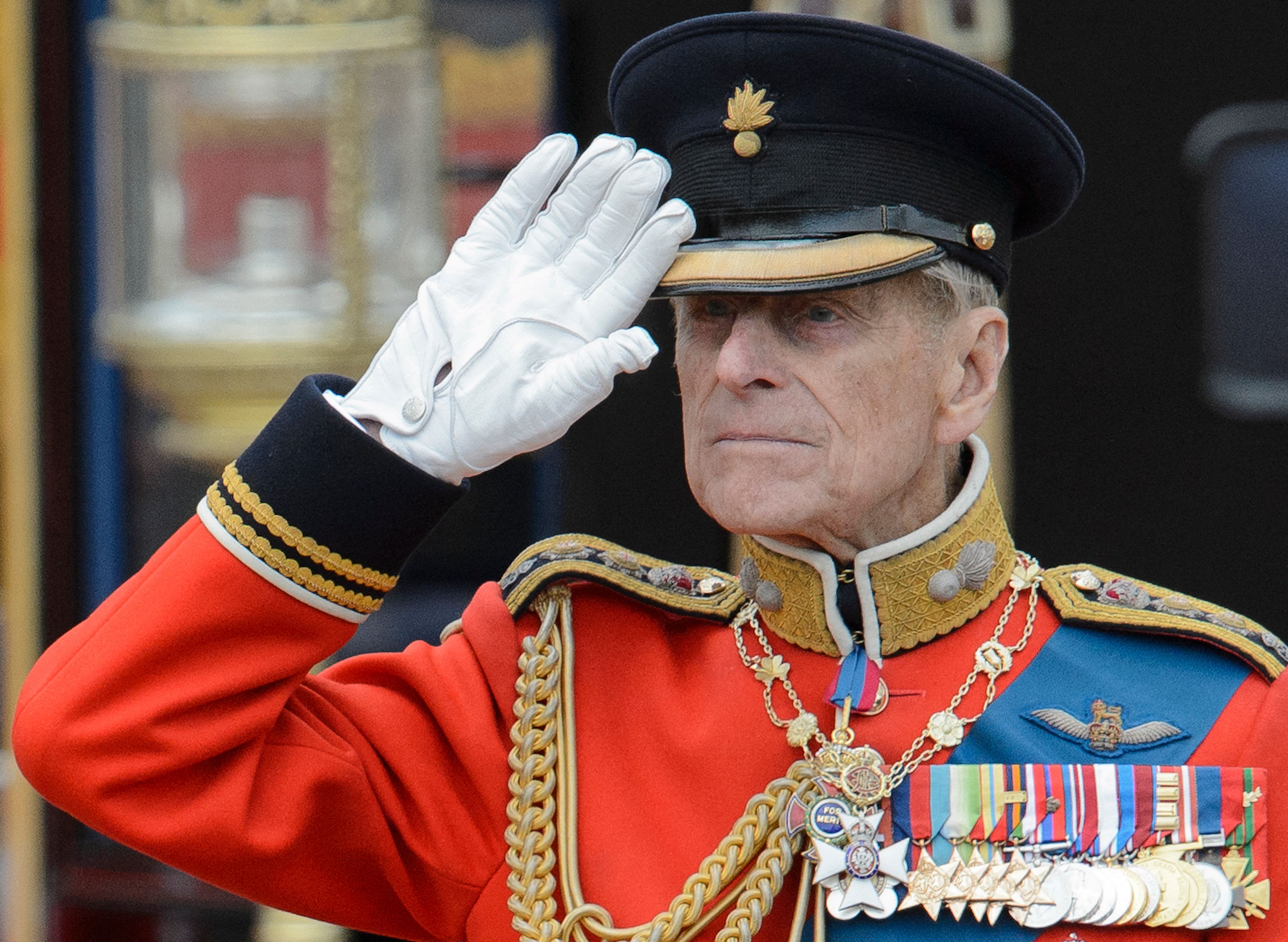 (FILES) In this file photo taken on June 16, 2012 Britain's Prince Philip, Duke of Edinburgh salutes as he watches the troops ride past outside Buckingham Palace following the Queen's Birthday Parade, 'Trooping the Colour' at Horse Guards Parade in London on June 16, 2012. - Queen Elizabeth II's 99-year-old husband Prince Philip, who was recently hospitalised and underwent a successful heart procedure, died on April 9, 2021, Buckingham Palace announced. (Photo by LEON NEAL / AFP)