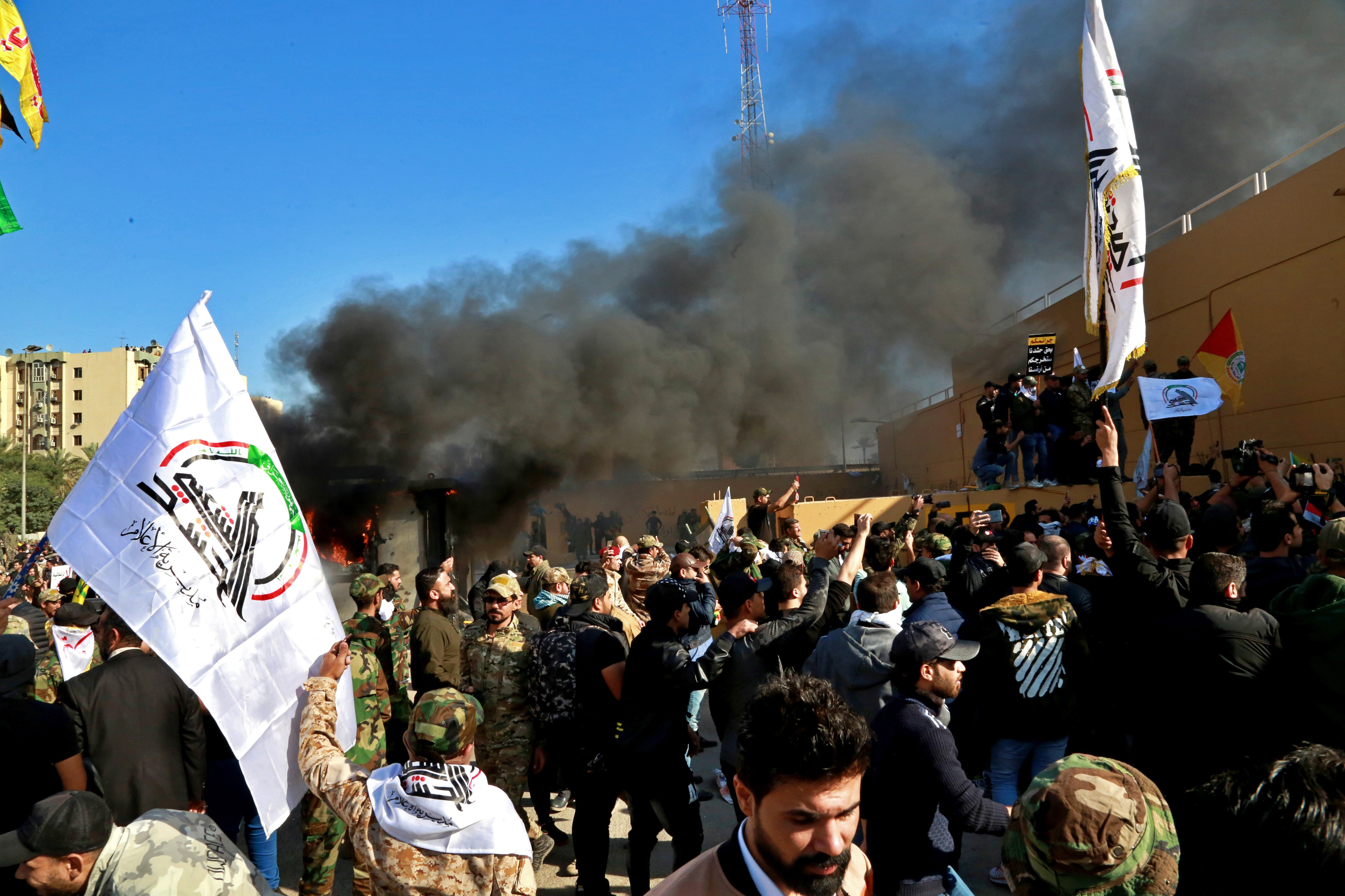 Protesters burn property in front of the U.S. embassy compound, in Baghdad, Iraq, Tuesday, Dec. 31, 2019. Dozens of angry Iraqi Shiite militia supporters broke into the U.S. Embassy compound in Baghdad on Tuesday after smashing a main door and setting fire to a reception area, prompting tear gas and sounds of gunfire. (AP Photo/Khalid Mohammed)