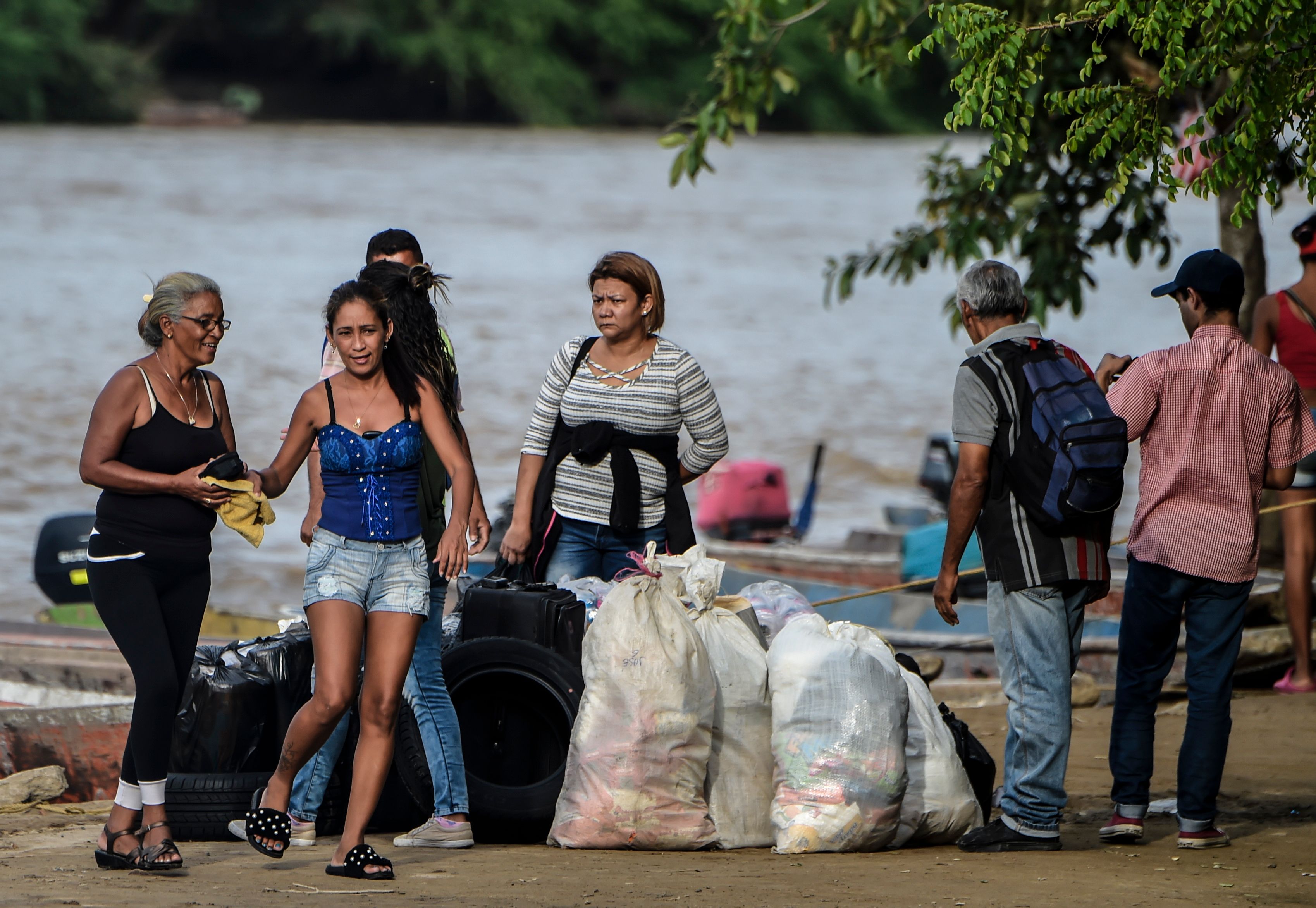 Venezuelans buy food on the banks of the Arauca River in Arauca, Colombia, on border with Venezuela, on May 15, 2019. - Venezuelan migrants find anti-personnel mines, forced recruitment of armed groups, trafficking networks in Colombia. Vulnerable, the migrants are cannon fodder of all traffics. (Photo by Juan BARRETO / AFP)