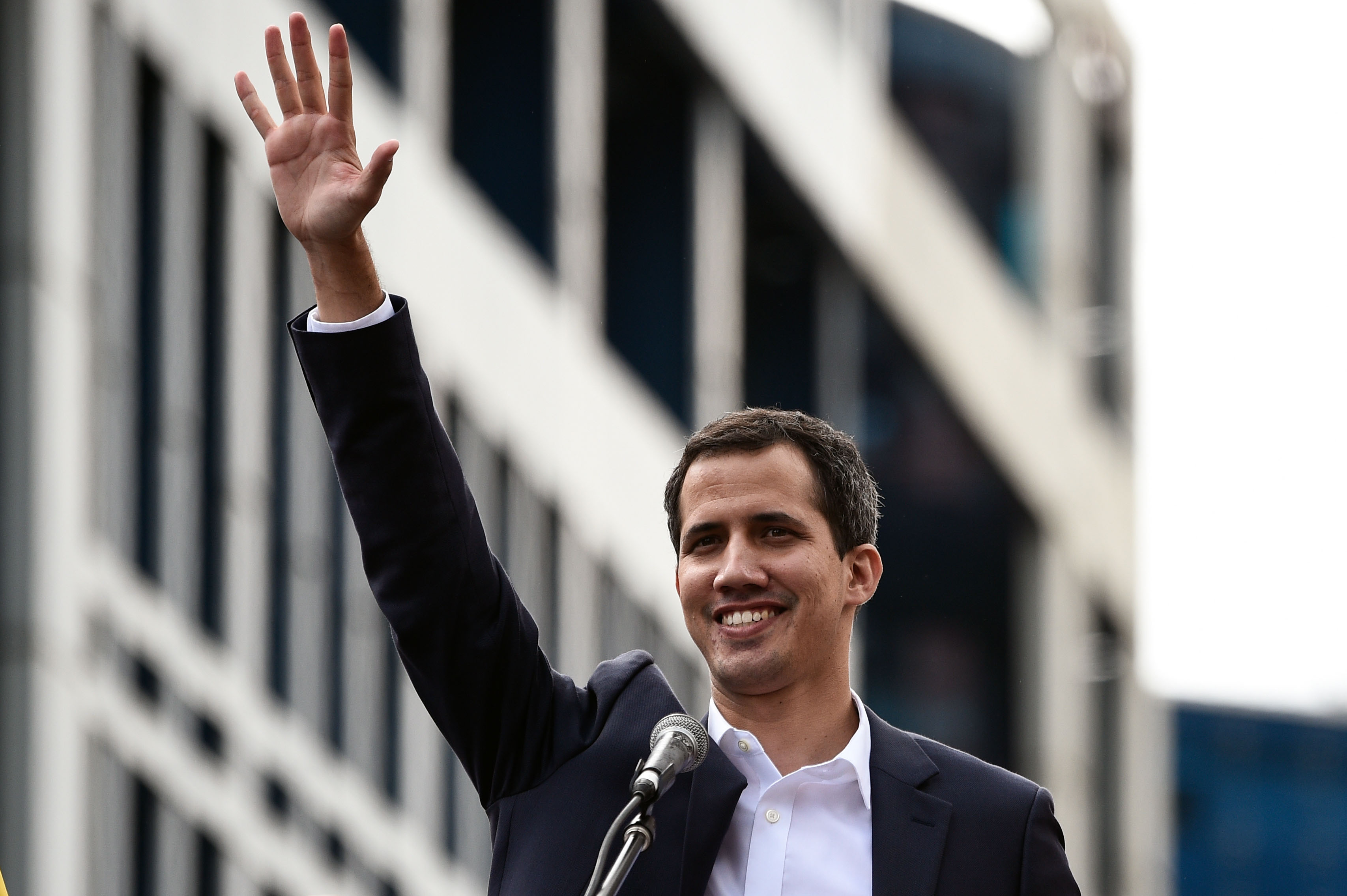 Venezuela's National Assembly head Juan Guaido waves to the crowd during a mass opposition rally against leader Nicolas Maduro in which he declared himself the country's "acting president", on the anniversary of a 1958 uprising that overthrew military dictatorship, in Caracas on January 23, 2019. - "I swear to formally assume the national executive powers as acting president of Venezuela to end the usurpation, (install) a transitional government and hold free elections," said Guaido as thousands of supporters cheered. Moments earlier, the loyalist-dominated Supreme Court ordered a criminal investigation of the opposition-controlled legislature. (Photo by Federico PARRA / AFP)