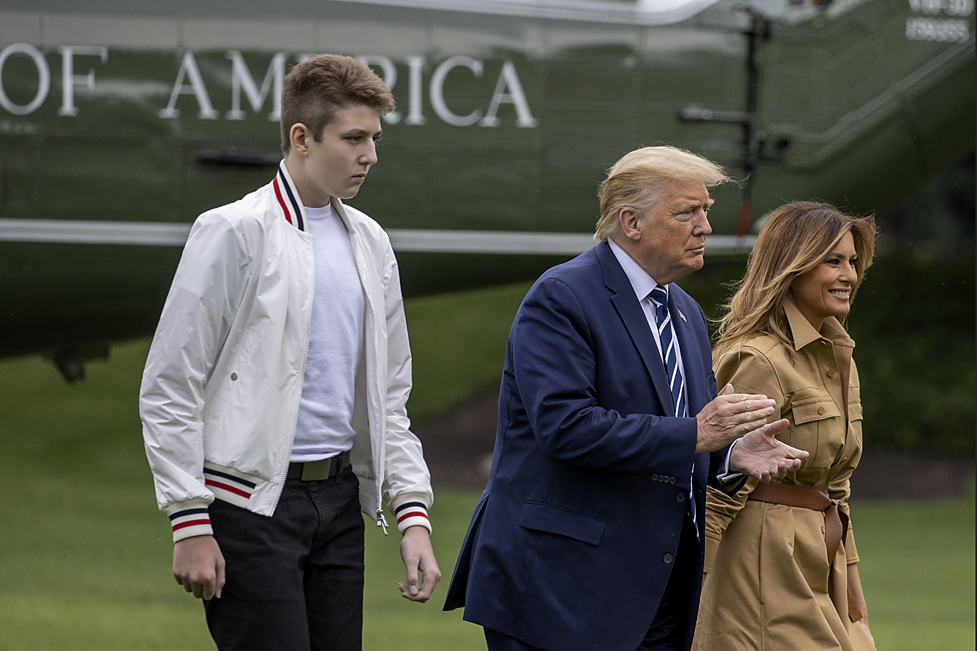 (FILES) In this file photo taken on August 16, 2020, Barron Trump, US President Donald Trump and First lady Melania Trump walk on the South Lawn of the White House in Washington, DC. - President Donald Trump's teenage son Barron contracted Covid-19 after both his parents tested positive, but is now negative, First Lady Melania said on October 14, 2020. She said that after she and the president tested positive two weeks ago, "Naturally my mind went immediately to our son." Barron Trump, 14, first tested negative, then positive, but showed no symptoms. "He has since tested negative," the first lady wrote in an essay entitled "My Personal Experience with Covid-19." (Photo by TASOS KATOPODIS / GETTY IMAGES NORTH AMERICA / AFP)