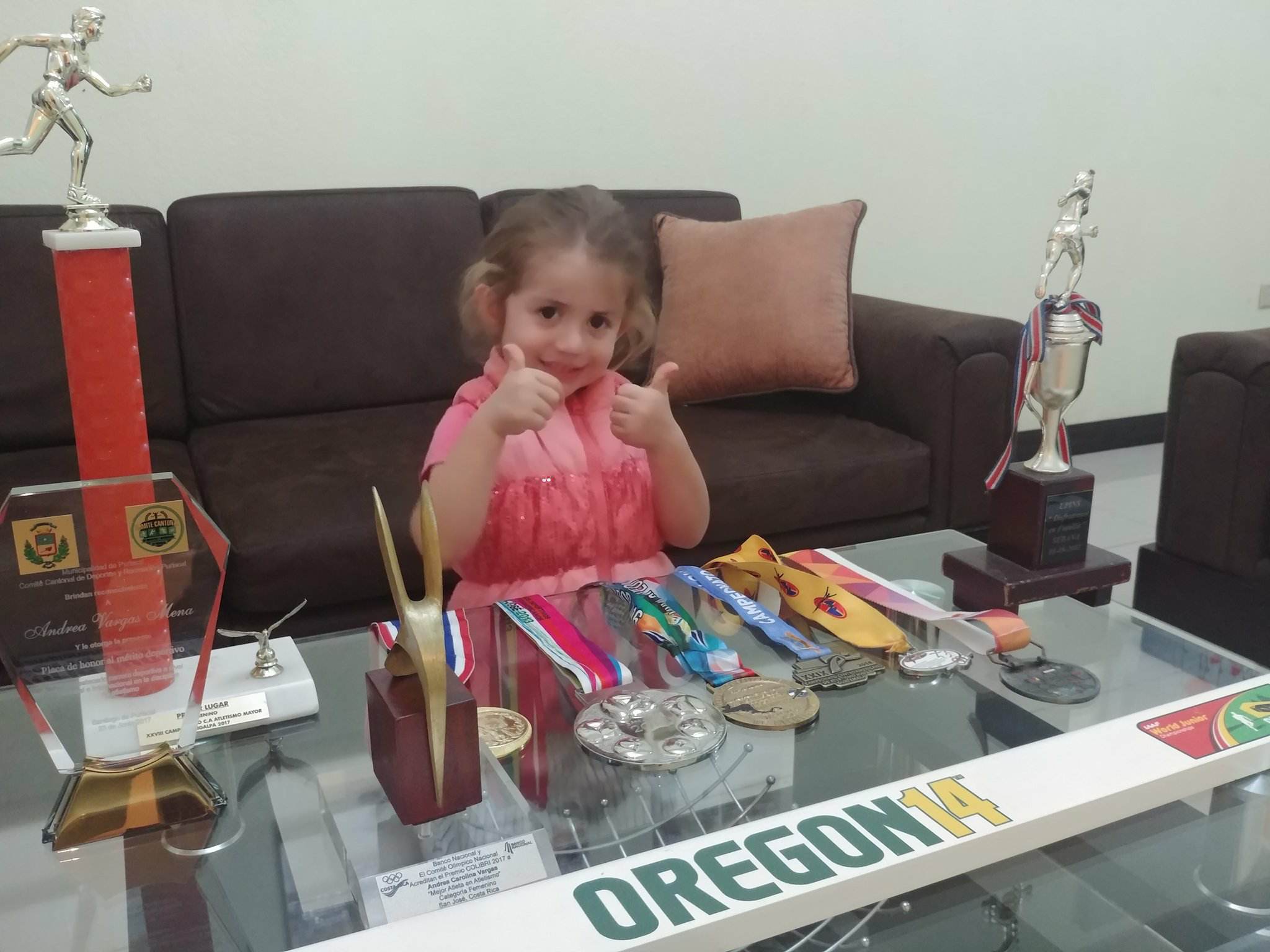 Avril posó con las medallas que ha conseguido su mamá en su carrera deportiva. Fotografía: Cortesía de la familia.