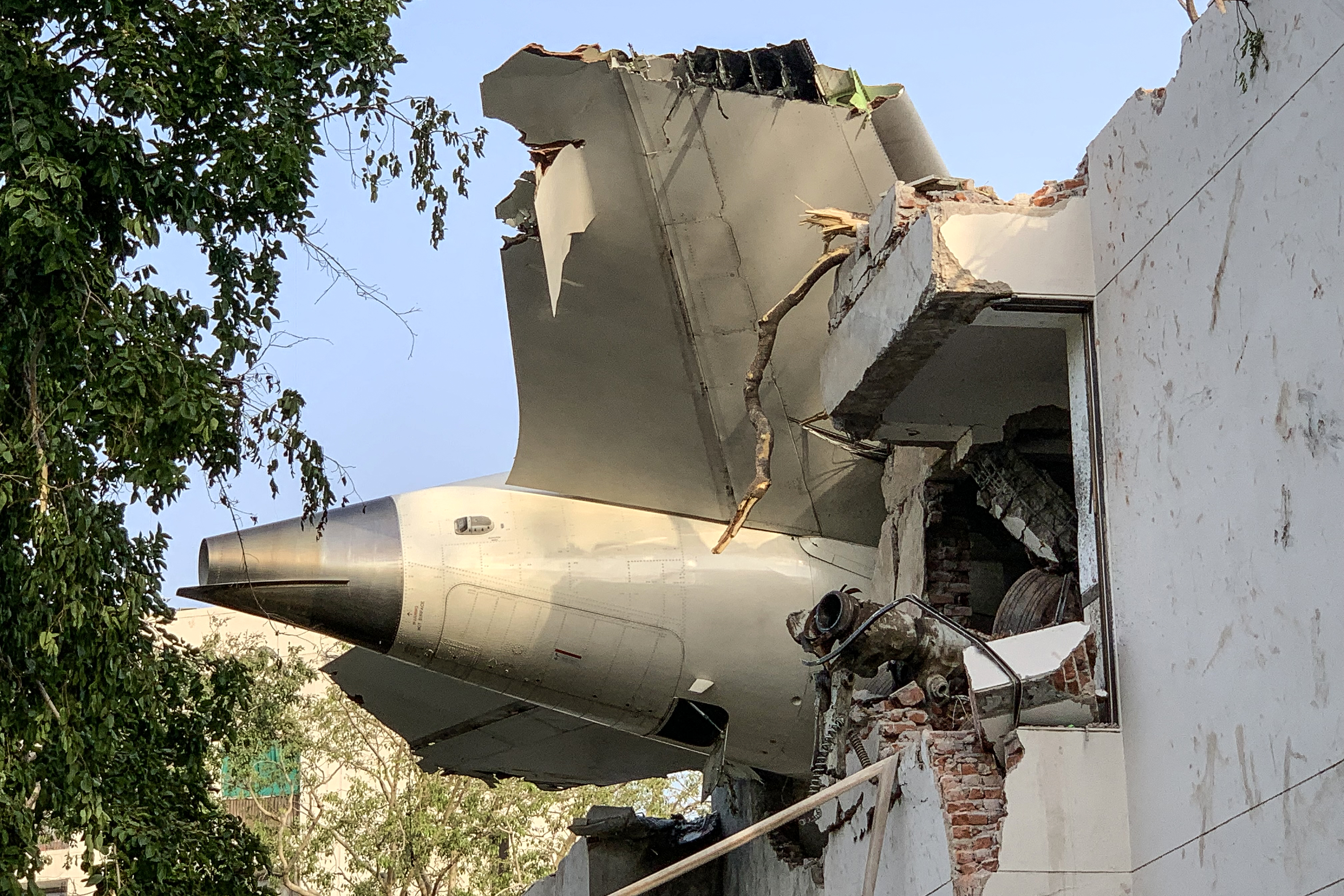 La parte trasera del vuelo 171 de Air India aparece en la imagen en el lugar del accidente, ocurrido en una zona residencial cerca del aeropuerto en Ahmedabad, el 12 de junio de 2025. Un avión de pasajeros con destino a Londres se estrelló en la ciudad india de Ahmedabad ese día, y se cree que las 242 personas a bordo murieron, luego de que la aeronave impactara contra edificios donde vivían médicos y sus familias. (Foto de Sam PANTHAKY / AFP)