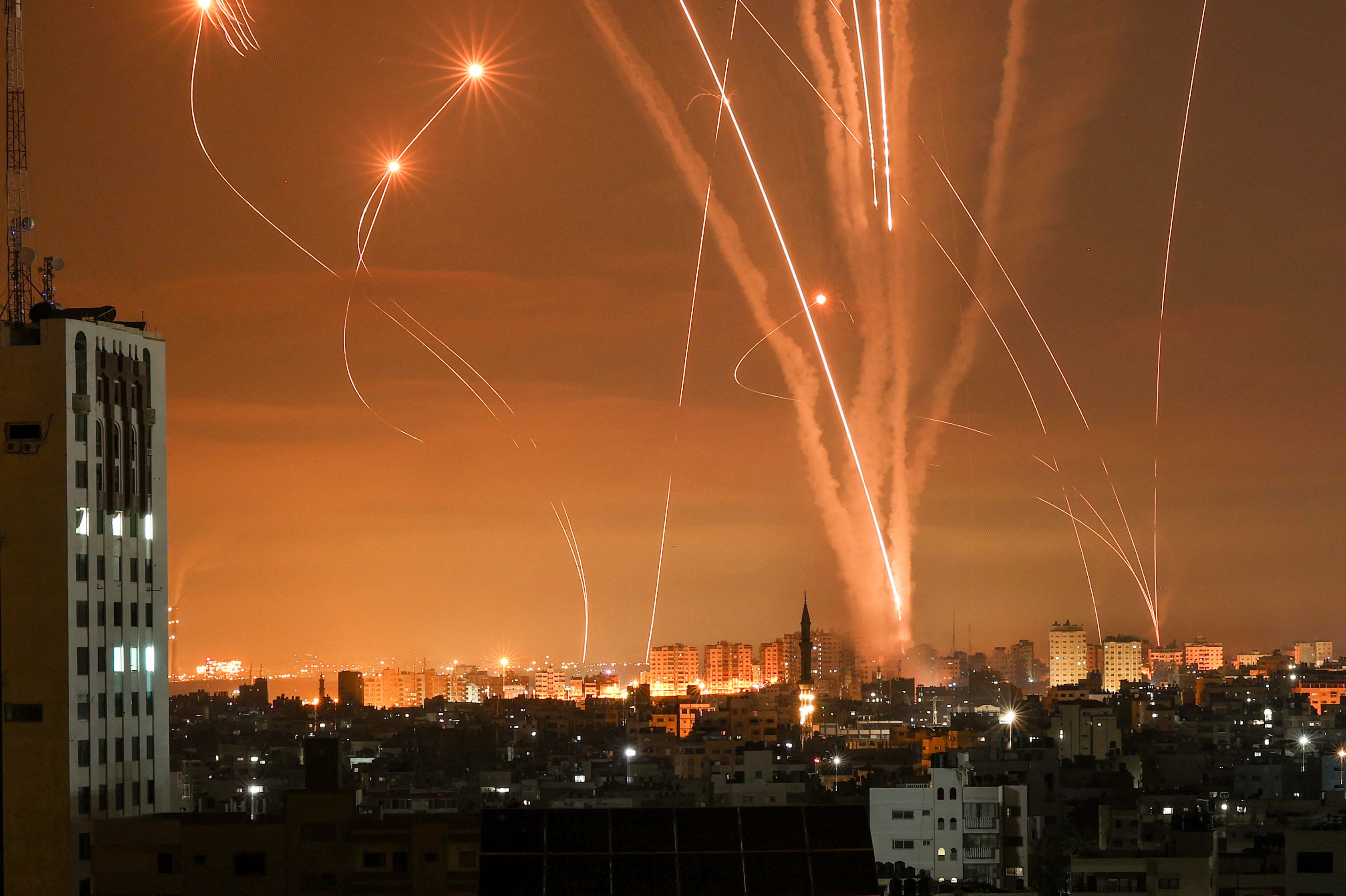 Rockets light up the night sky as they are fired towards Israel from Beit Lahia in the northern Gaza Strip on May 14, 2021. - Israel pounded Gaza and deployed extra troops to the border as Palestinians fired barrages of rockets back, with the death toll in the enclave on the fourth day of conflict climbing to over 100. (Photo by MOHAMMED ABED / AFP)