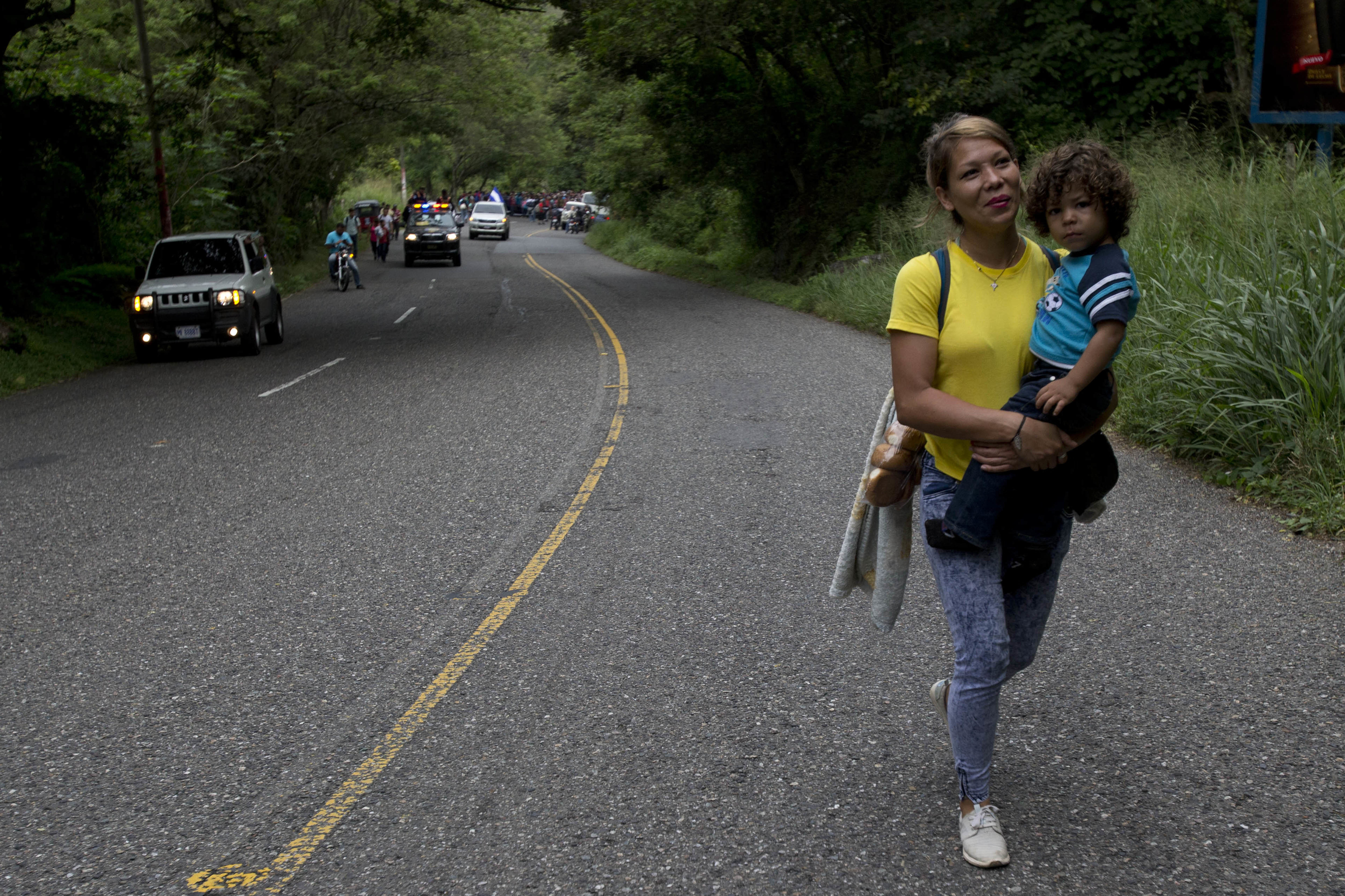 Honduran migrant Mary Dominguez, 27, carries her two-year-old son Dominic during a caravan of hundreds of Honduras migrants making their way to the U.S., as the group leaves Esquipulas, Guatemala, Tuesday, Oct. 16, 2018. U.S. President Donald Trump threatened on Tuesday to cut aid to Honduras if it doesn’t stop the impromptu caravan of migrants, but it remains unclear if governments in the region can summon the political will to physically halt the determined border-crossers. (AP Photo/Moises Castillo)