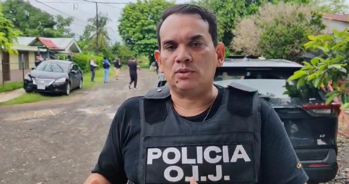 Randall Zúñiga, director del OIJ, con chaleco de la Policía Judicial, habla frente a la cámara en un entorno urbano, en respuesta a declaraciones del presidente Rodrigo Chaves sobre el presupuesto de la institución.