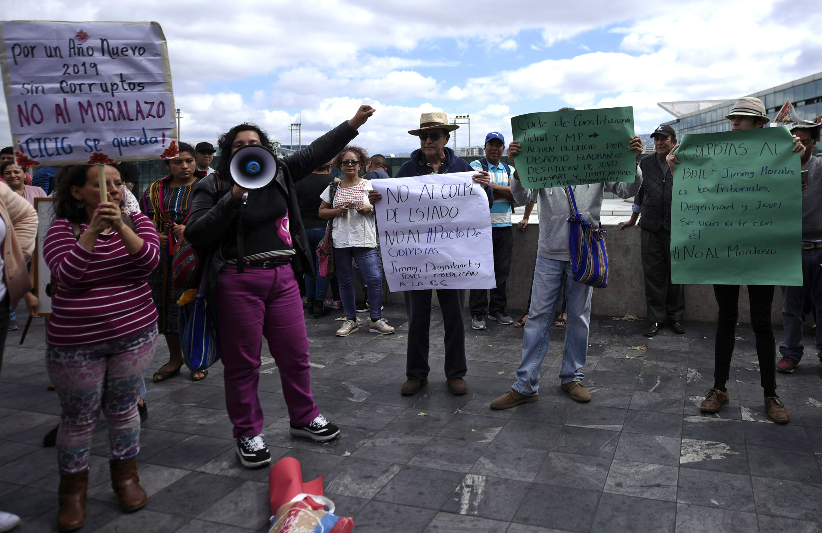 People rally to show support for the International Commission Against Impunity in Guatemala (CICIG) outside La Aurora International Airport in Guatemala City, Sunday, Jan. 6, 2019. Authorities are holding Colombian Yilen Osorio, a member of CICIG in the capital's airport, refusing him entry to the country in an escalation of tensions between the government and the commission. (AP Photo/Santiago Billy)