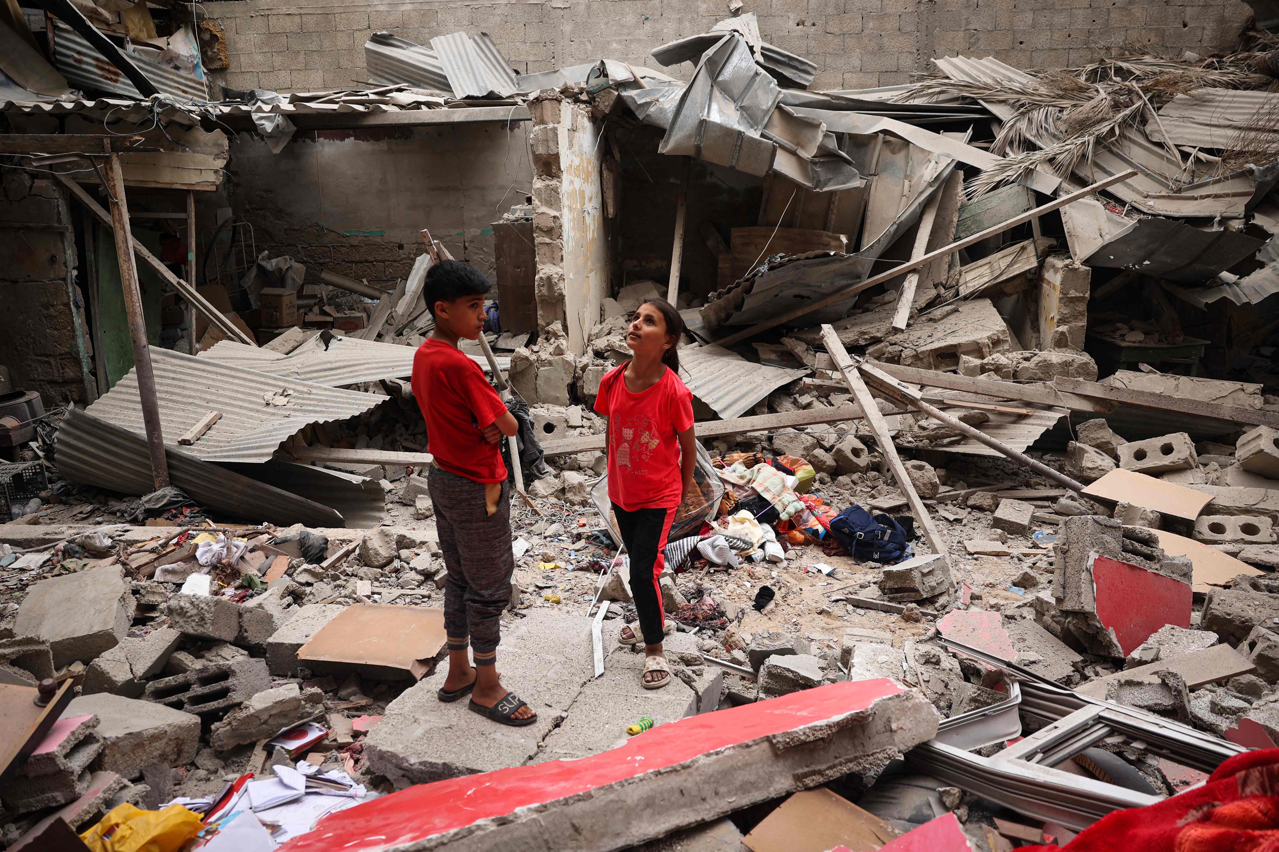 TOPSHOT - Palestinian children stand amid the debris of a house destroyed by overnight Israeli bombardment in Rafah in the southern Gaza Strip on April 27, 2024, as the conflict between Israel and the militant group Hamas continues. (Photo by AFP)