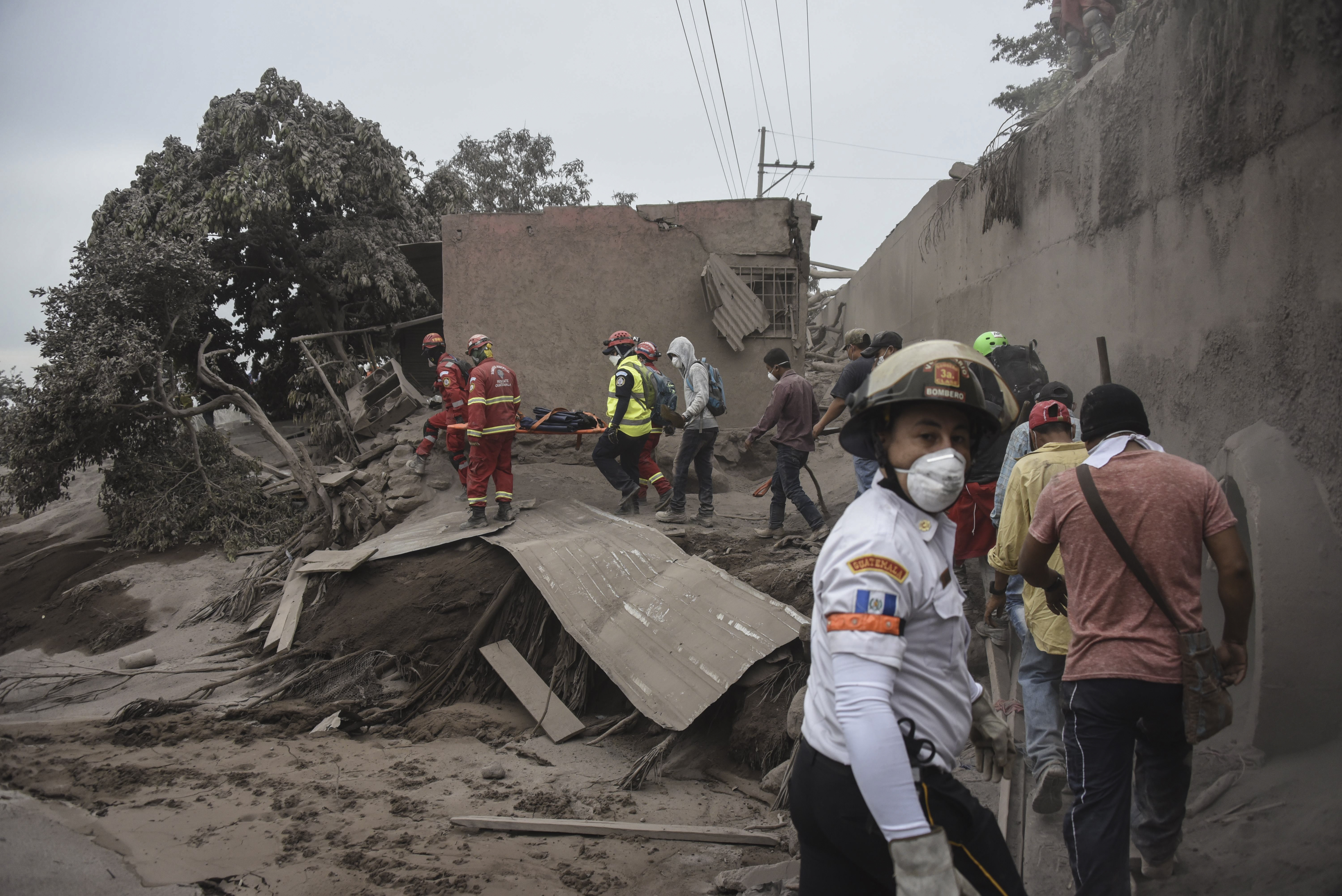 Rescuers search for victims in San Miguel Los Lotes, a village in Escuintla Department, about 35 km southwest of Guatemala City, on June 4, 2018, a day after the eruption of the Fuego Volcano
At least 25 people were killed, according to the National Coordinator for Disaster Reduction (Conred), when Guatemala's Fuego volcano erupted Sunday, belching ash and rock and forcing the airport to close. / AFP PHOTO / Johan ORDONEZ