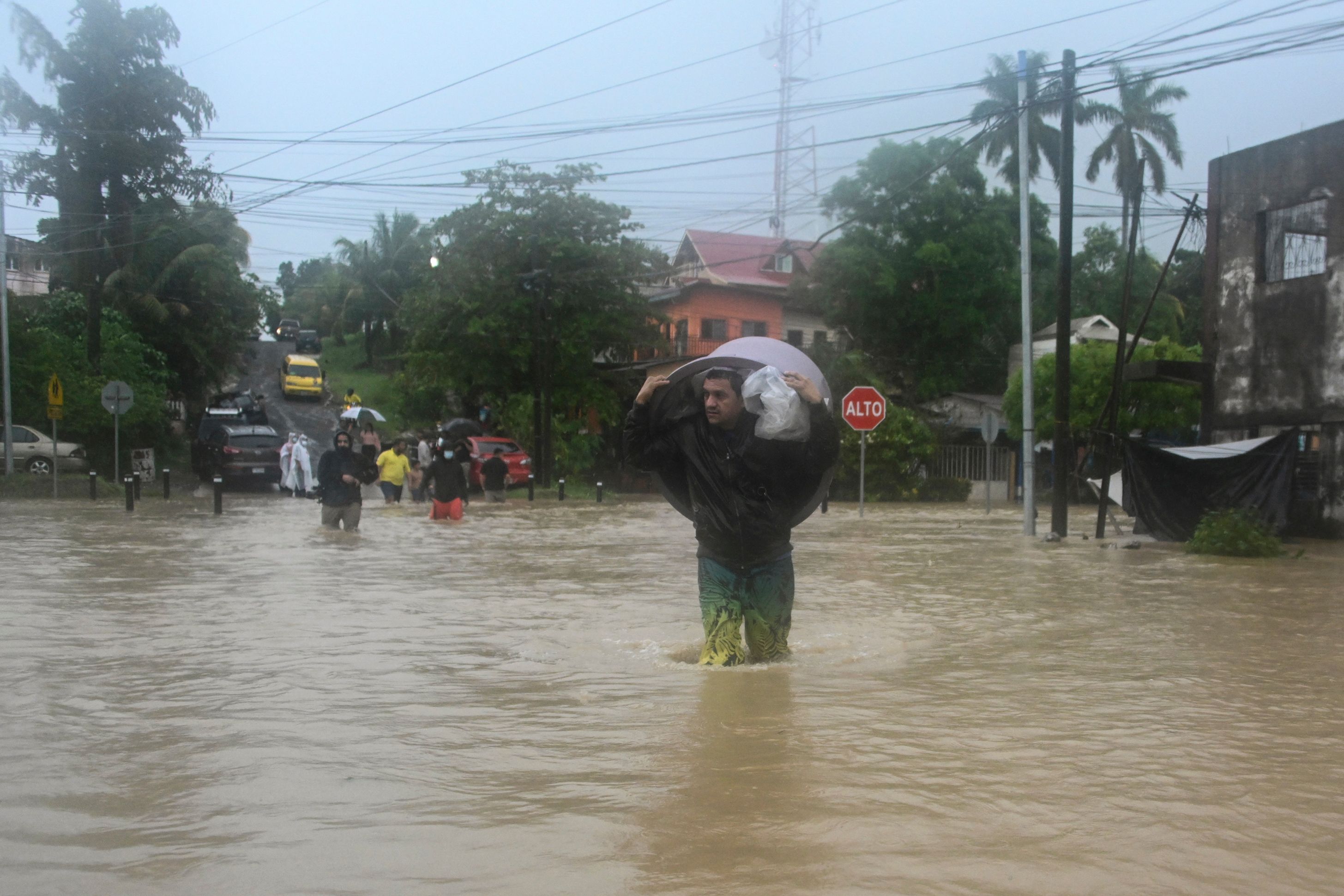 A man wades through a flooded street due to the heavy rains caused by Hurricane Eta, now degraded to a tropical storm, in Puerto Barrios, Izabal 310 km north Guatemala City on November 5, 2020. - At least four people, including two children, died in landslides as tropical storm Eta swept through Guatemala, civil protection officials said Thursday. The deaths brought the toll in Central America to eight after Eta tore into northern Nicaragua as a Category 4 hurricane on Tuesday causing mudslides that killed two miners, as well as two young girls in neighboring Honduras. (Photo by Johan ORDONEZ / AFP)