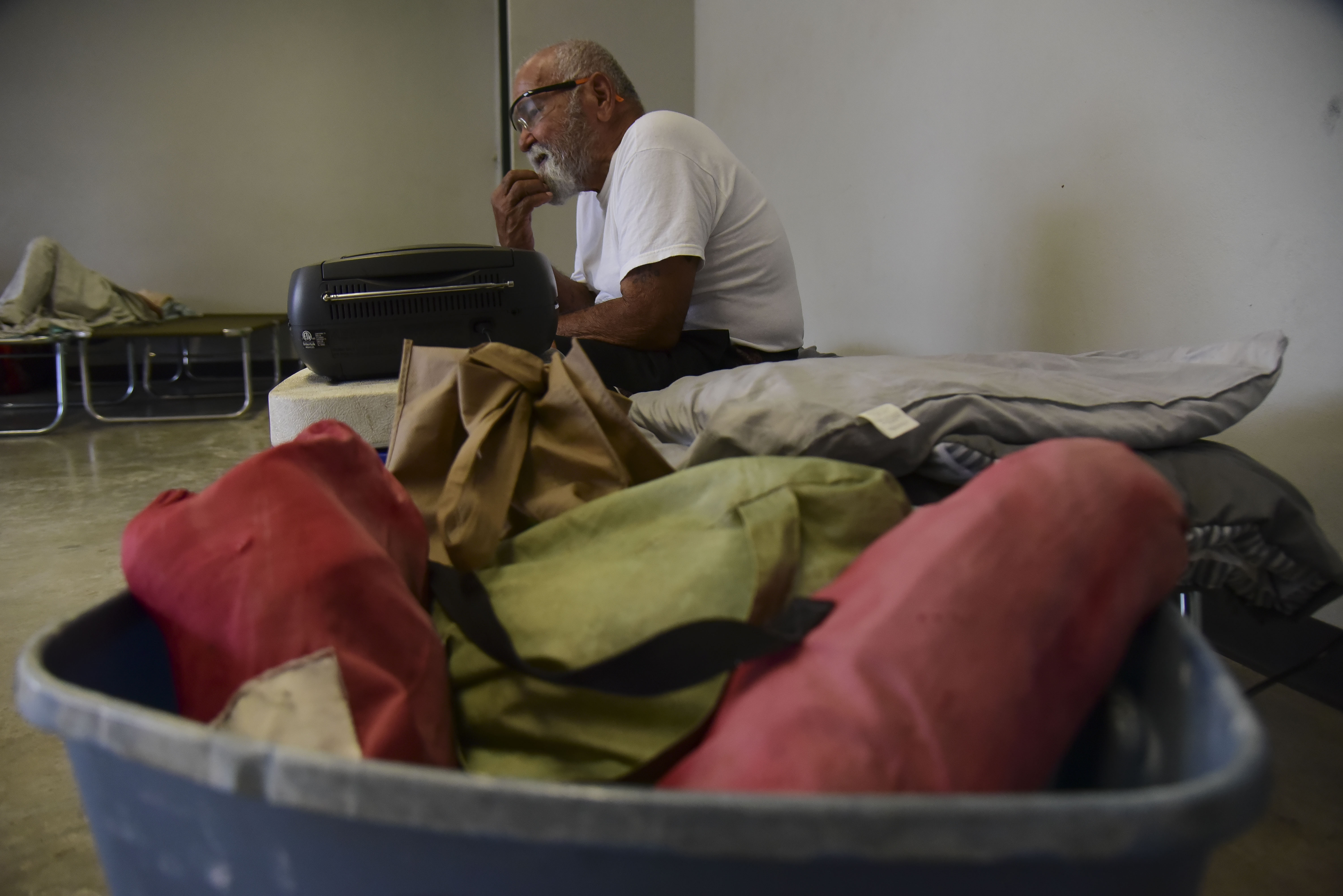 Victor Ortiz Martinez, 79, sits on a cot at the William Rivera Vocational School converted into a temporary shelter, before the arrival of Tropical Storm Dorian, in Canovanas, Puerto Rico, Wednesday, Aug. 28, 2019. Dorian became a Category 1 hurricane on Wednesday as it struck the U.S. Virgin Islands, with forecasters saying it could grow to Category 3 status as it nears the U.S. mainland as early as the weekend. (AP Photo/Carlos Giusti)