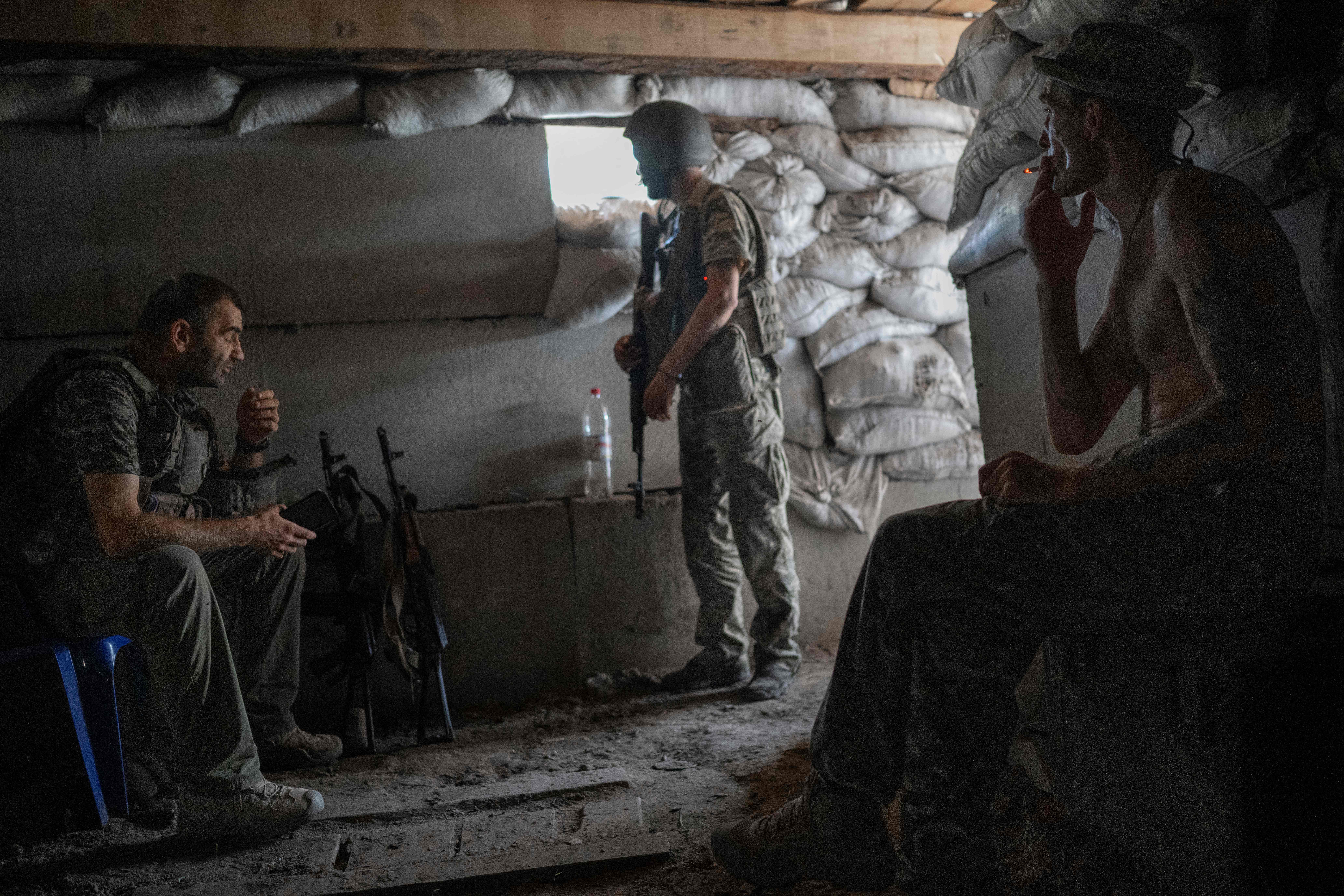 Ukranian soldiers sit at their position in their basement base, close to the frontline, in southern Ukraine on August 20, 2022, as the Russia-Ukraine war enters its 178th day. (Photo by BULENT KILIC / AFP)