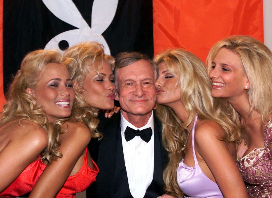 En esta imagen de 1999, Hugh Hefner es besado por sus "conejitas" de 'Playboy' durante el Festival de Cannes.