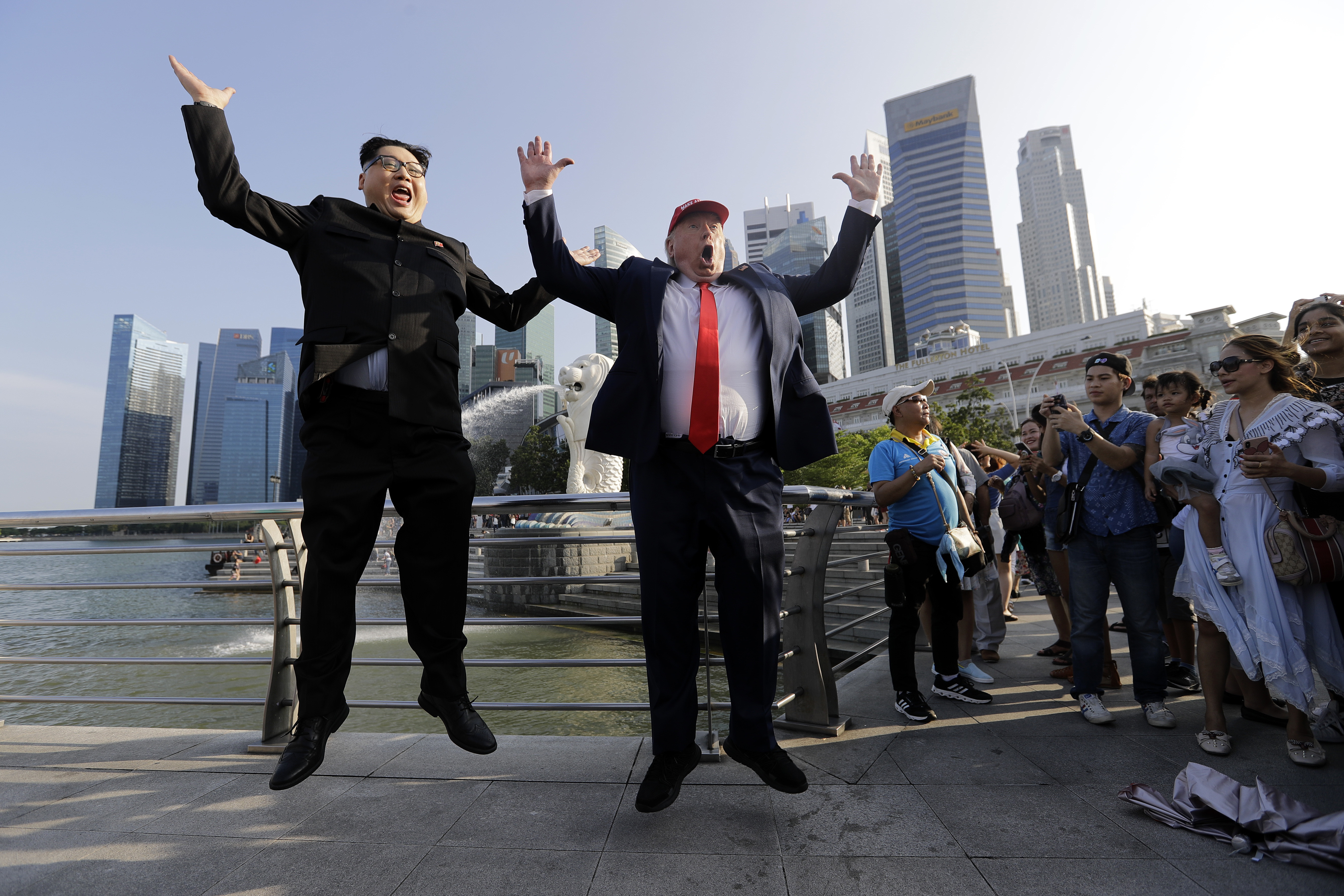 Los imitadores de Kim Jong-un y Donald Trump, Howard X (der.), y Dennis Alan (izq.) posan para fotografías durante su visita al Merlion Park, un popular destino turístico en Singapur, el viernes 8 de junio de 2018. AP
