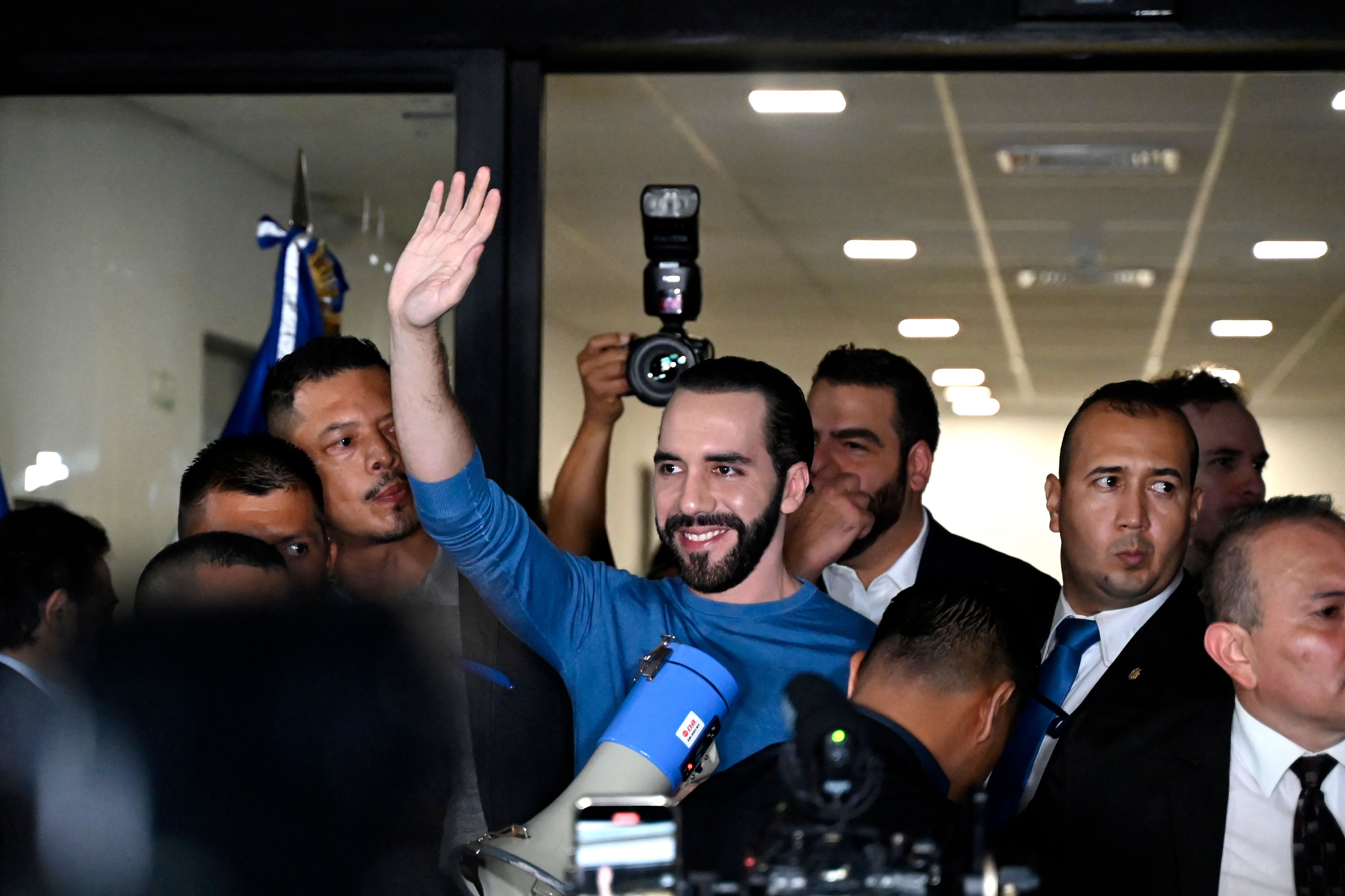 El Salvador's President Nayib Bukele (C) waves as he arrives to the Supreme Electoral Tribunal headquarters to register for the upcoming elections, in San Salvador, on October 26, 2023. (Photo by MARVIN RECINOS / AFP)