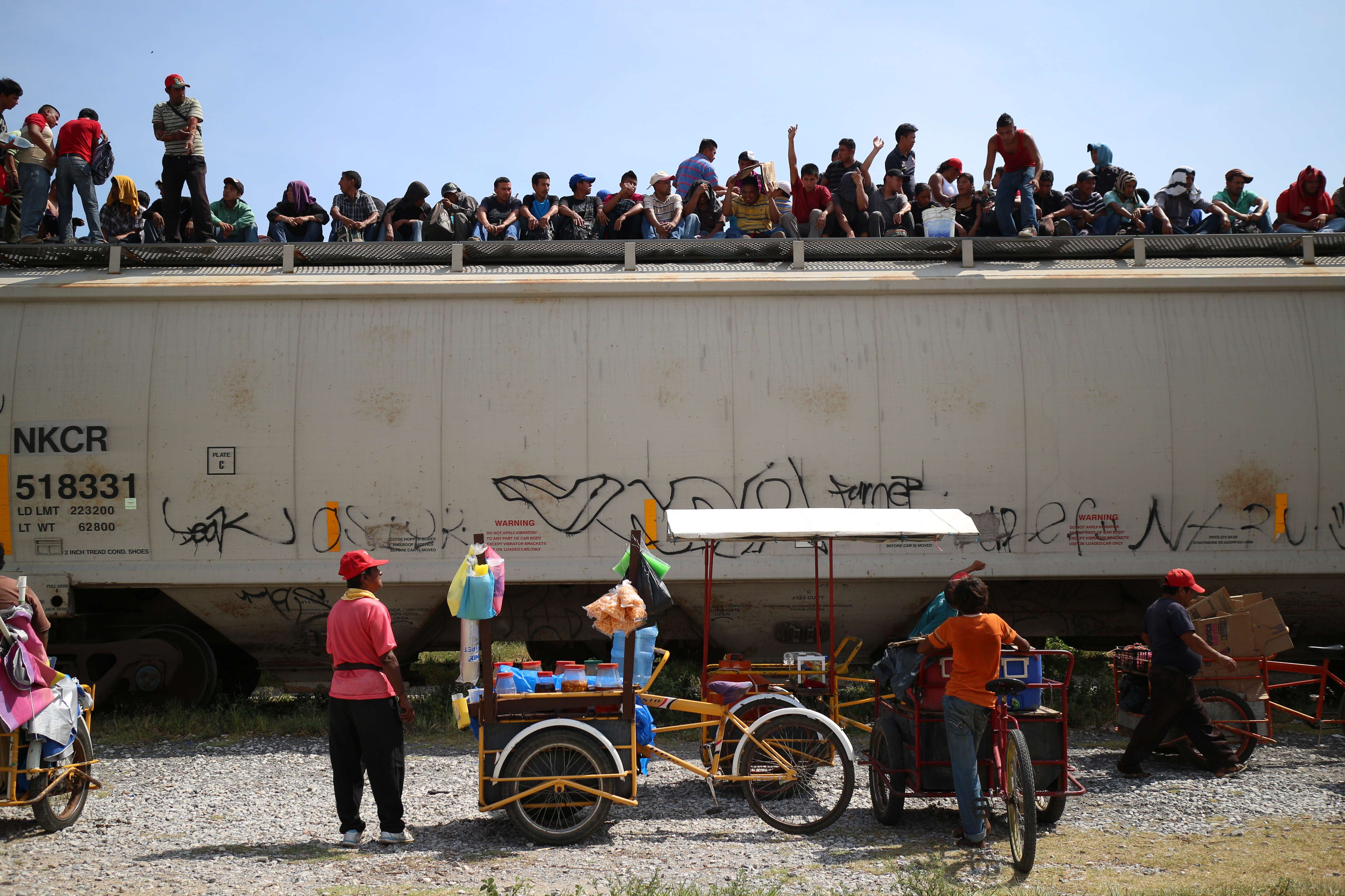 Central American immigrants sit atop the so-called La Bestia (The Beast) cargo train, in an attempt to reach the Mexico-US border, in Arriaga, Chiapas state, Mexico on July 16, 2014. AFP PHOTO/ELIZABETH RUIZ