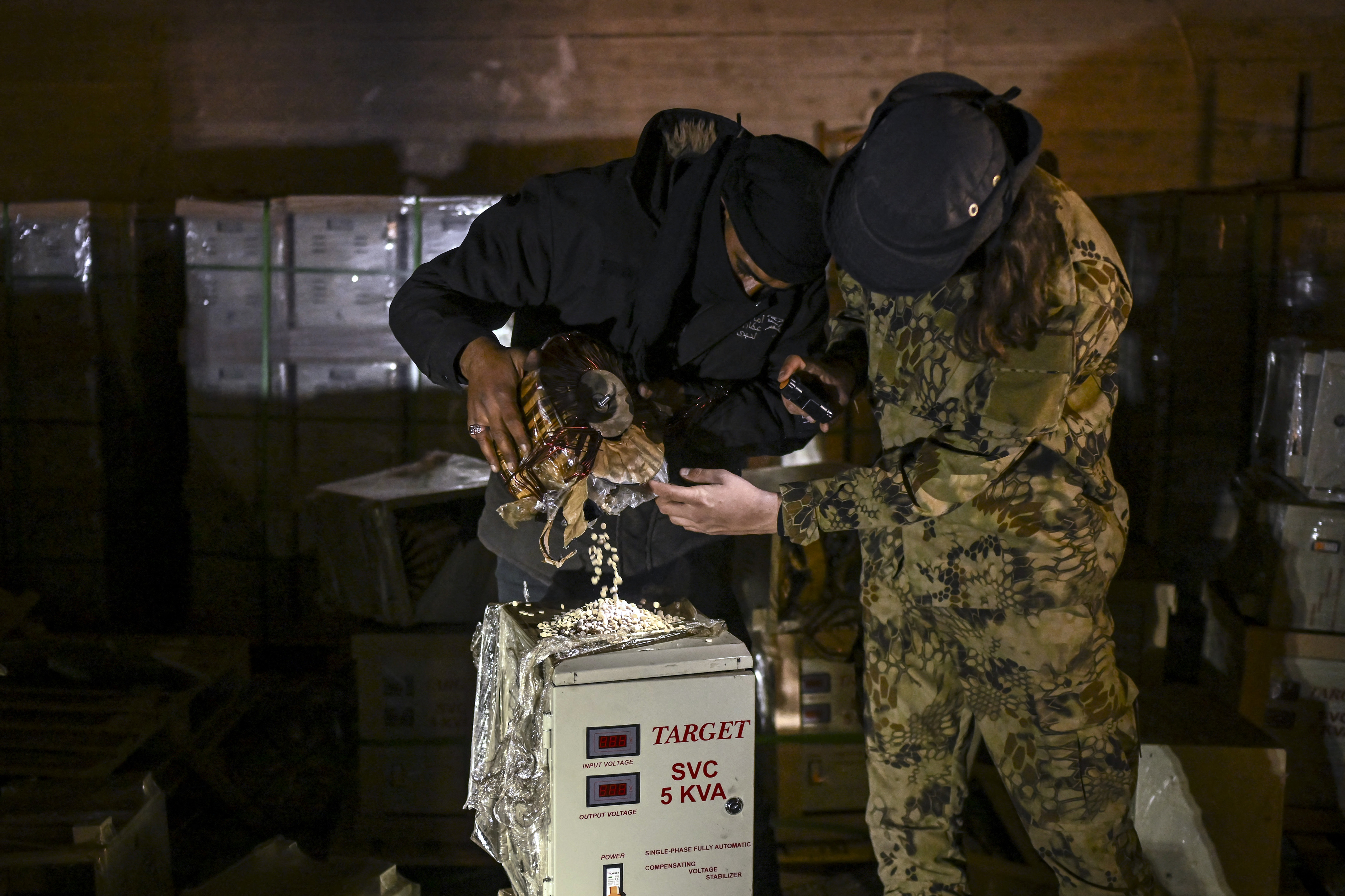 Combatientes de Hayat Tahrir al Sham inspeccionan píldoras de captagon escondidas en equipos eléctricos en Siria.