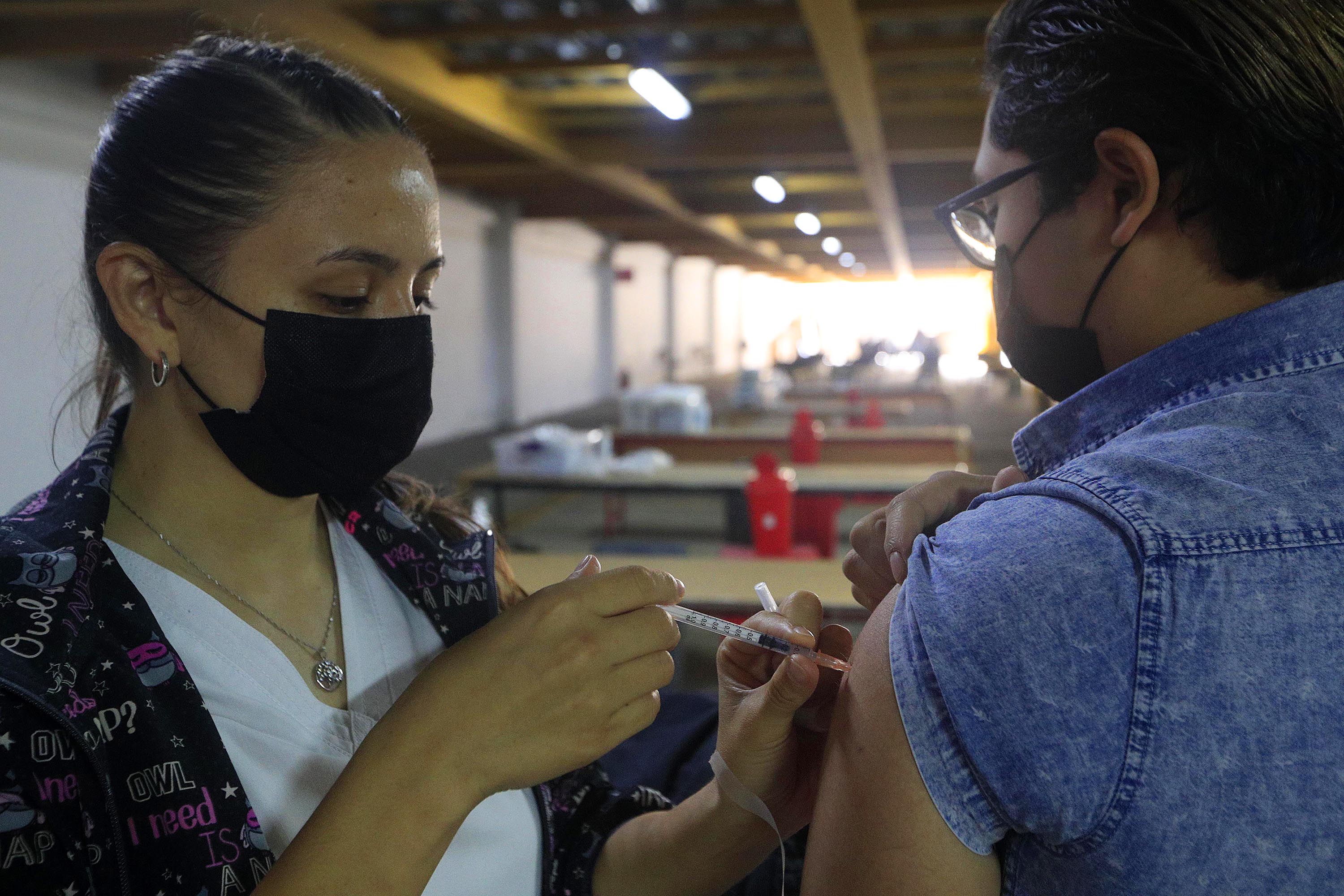 04/11/2021 San José. Estudiantes de la Universidad Internacional de las Américas (UIA) trabajan como voluntarios bajo la modalidad de Trabajo Comunal Univesitario (TCU) como apoyo en el centro de vacunación. El pasado jueves colaboraban con el personal médico que aplicaba segundas dosis de las vacunas de Pfzer y AstraZeneca, en esfuerzo que realiza el país para alcanzar la inmunidad de rebaño contra la covid-19. La enfermera Vivian Monge le aplicó la vacuna a Odimar Pavón Pérez.