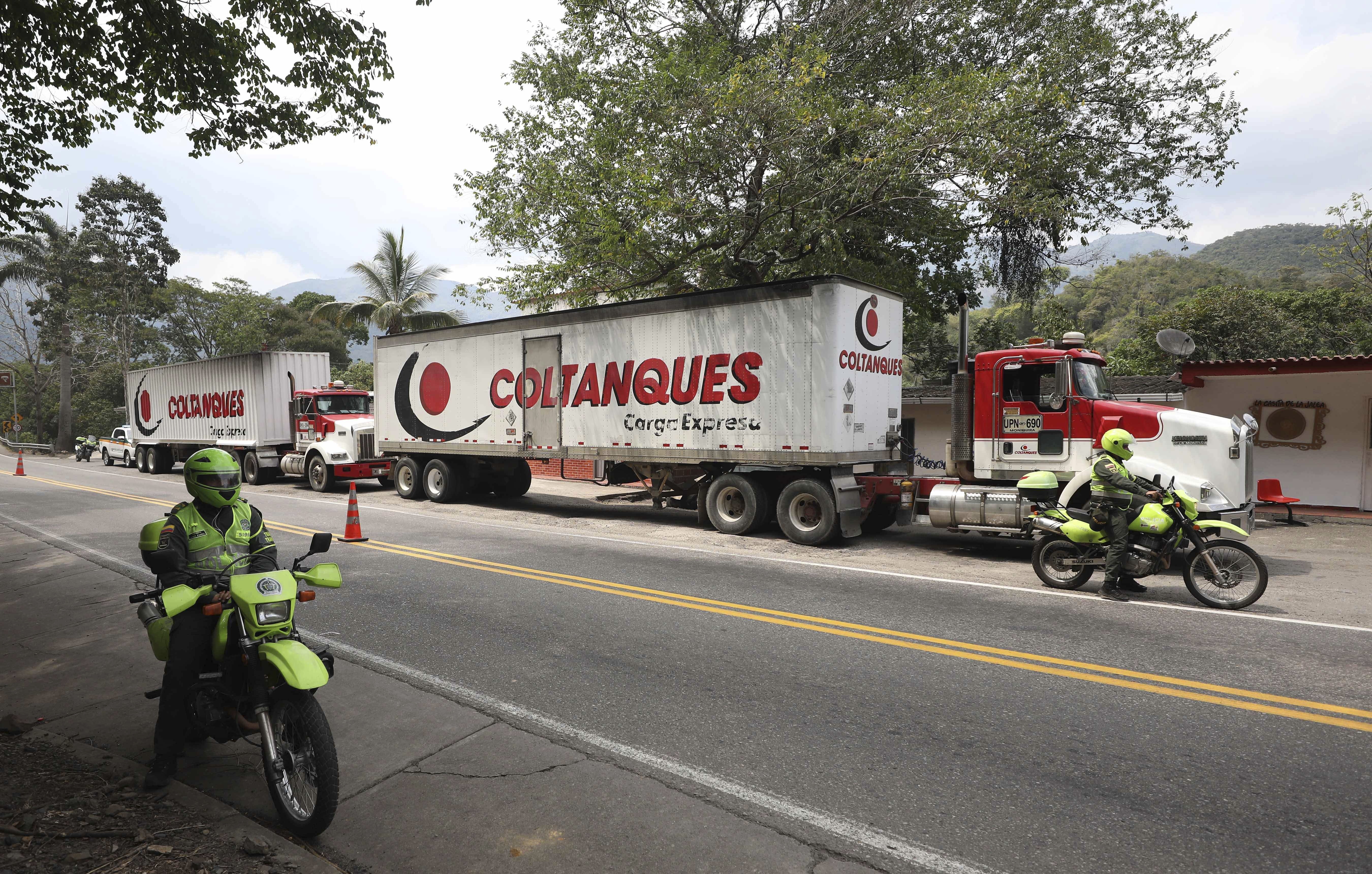 Two semi-trailer trucks containing humanitarian aid from the U.S for Venezuela are escorted by Colombian police in Los Patios, near Cucuta, Colombia, Thursday, Feb. 7, 2019, about 18 miles from the Colombian-Venezuelan border. (AP Photo/Fernando Vergara)