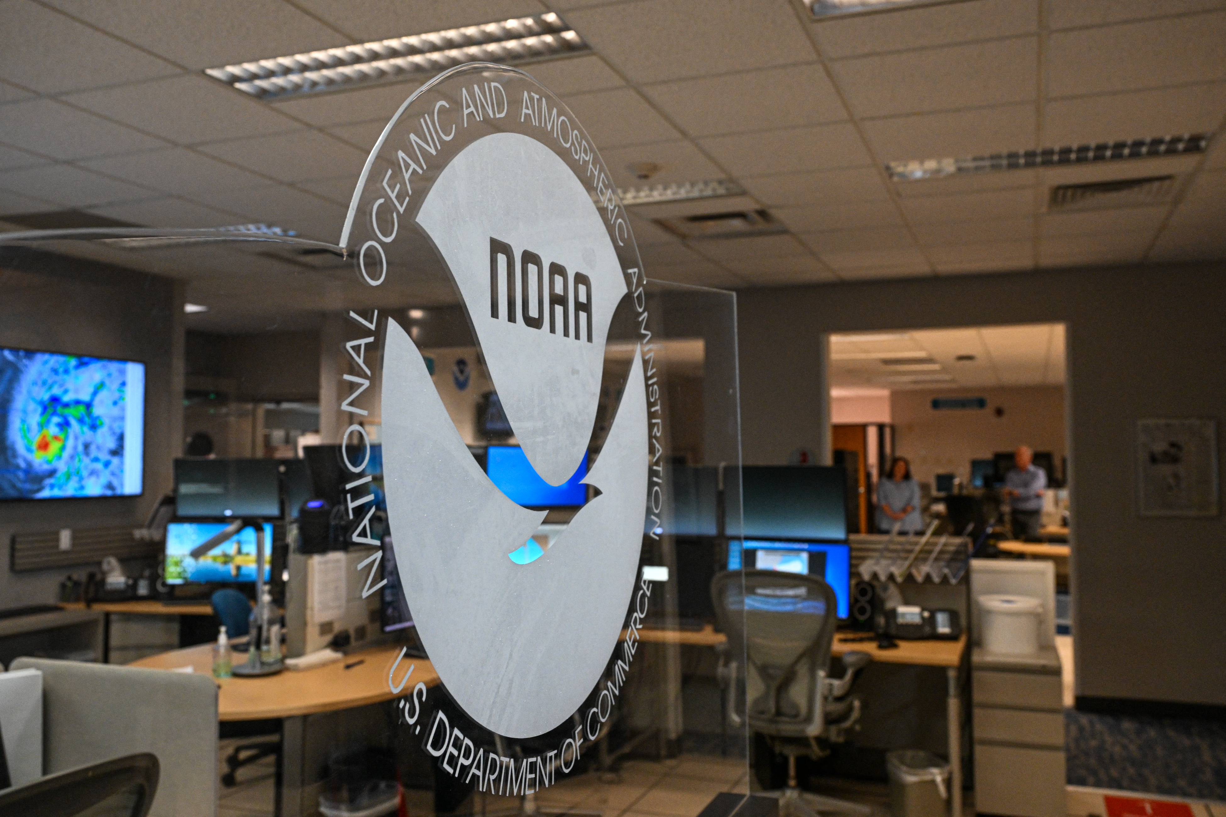 El logotipo de la Administración Nacional Oceánica y Atmosférica (NOAA) se observa durante una conferencia de prensa en el Centro Nacional de Huracanes en Miami, Florida, el 30 de mayo de 2025. La administración del presidente de Estados Unidos, Donald Trump, ha despedido a cientos de empleados de la NOAA y ha eliminado sitios web gubernamentales con datos sobre el clima y el tiempo. (Foto de CHANDAN KHANNA / AFP)