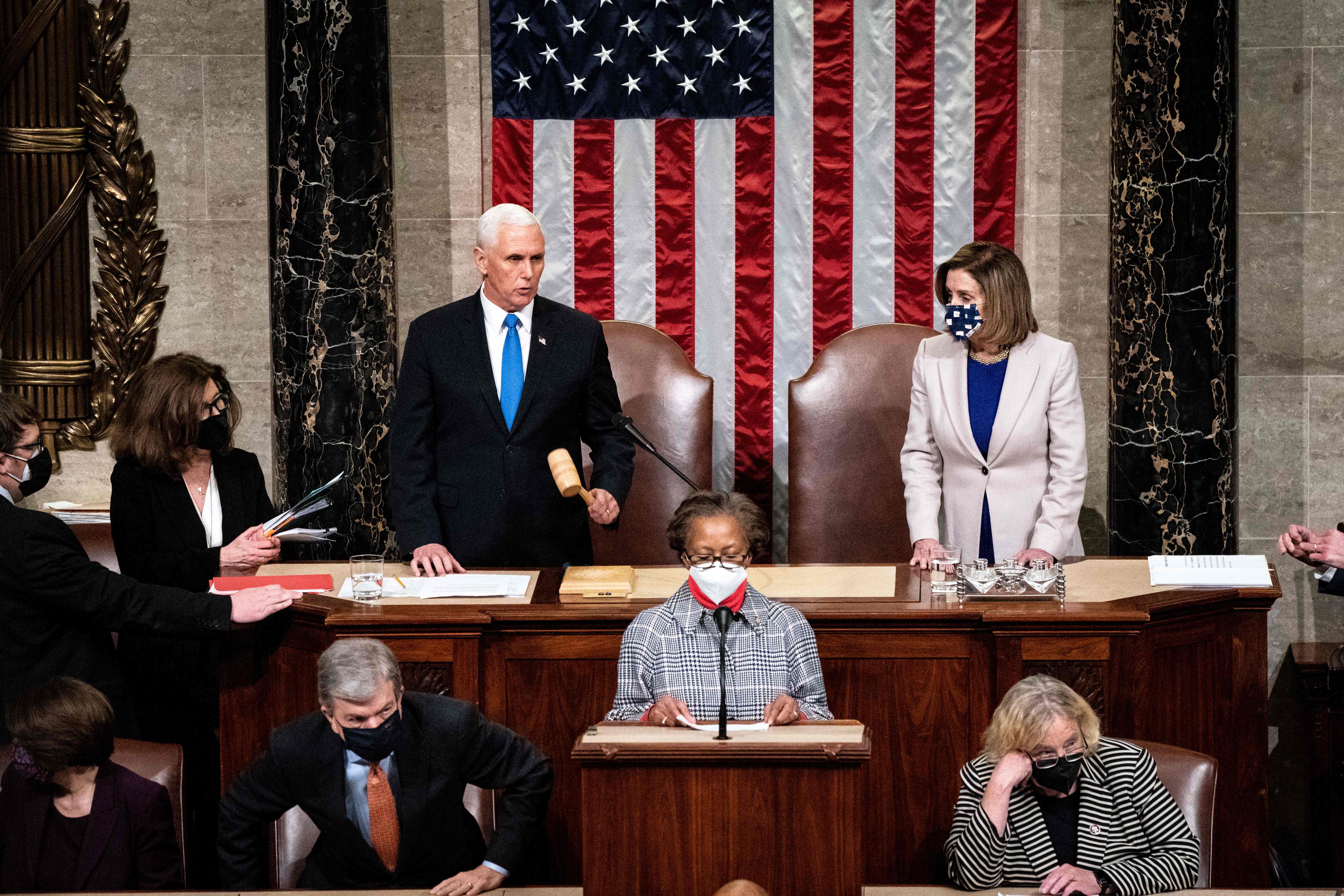 TOPSHOT - Vice President Mike Pence and House Speaker Nancy Pelosi preside over a Joint session of Congress to certify the 2020 Electoral College results after supporters of President Donald Trump stormed the Capitol earlier in the day on Capitol Hill in Washington, DC on January 6, 2020. - Members of Congress returned to the House Chamber after being evacuated when protesters stormed the Capitol and disrupted a joint session to ratify President-elect Joe Biden's 306-232 Electoral College win over President Donald Trump. (Photo by Erin Schaff / POOL / AFP)