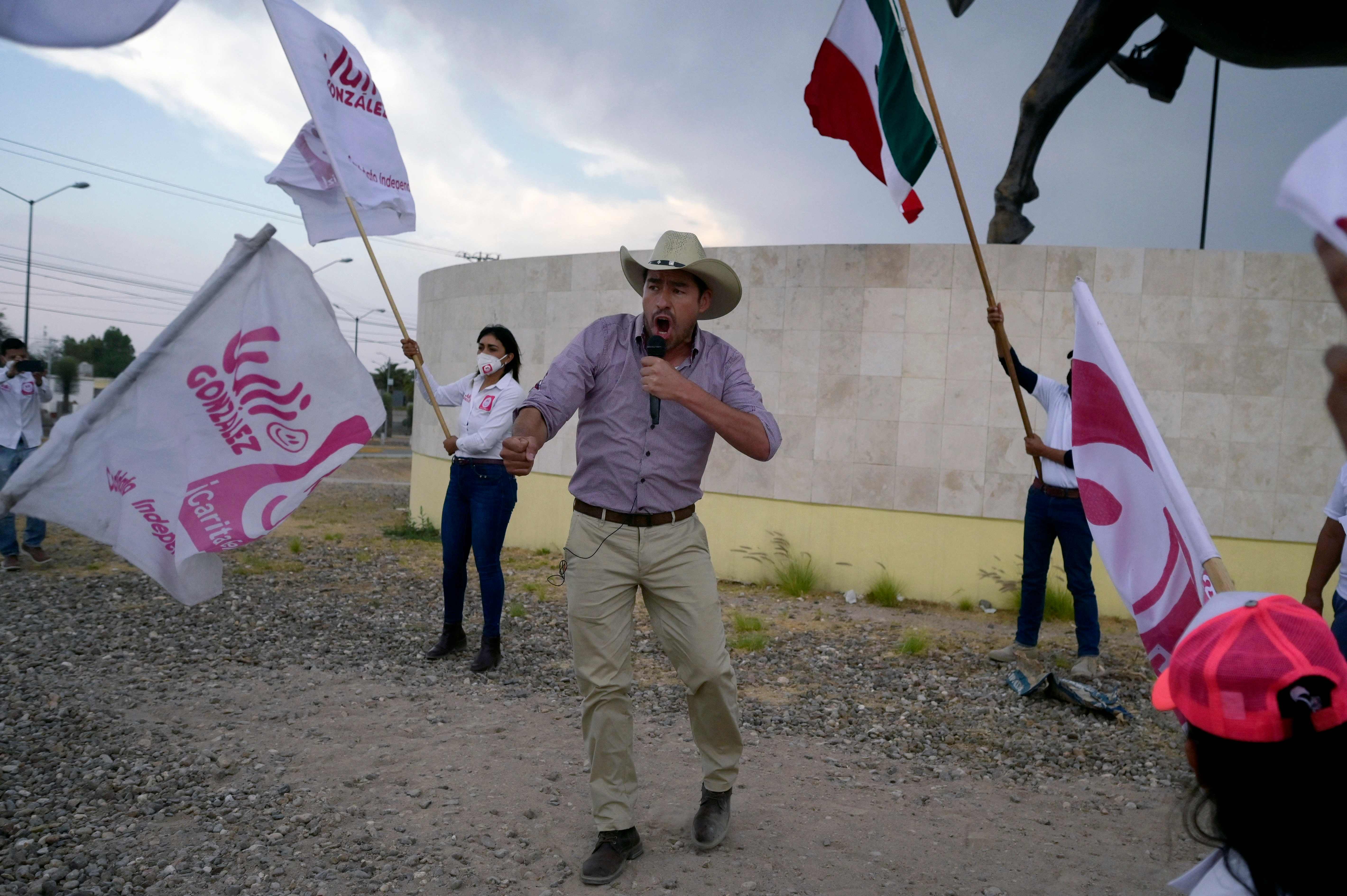 Independent mayoral candidate Julio Gonzalez (C) speaks to supporters during a campaign rally in Dolores Hidalgo, state of Guanajuato, Mexico on May 5, 2021. - Violence is rampant in the local Mexican electoral campaign with several candidates assassinated or threatened, as Julio Gonzalez. (Photo by ALFREDO ESTRELLA / AFP)