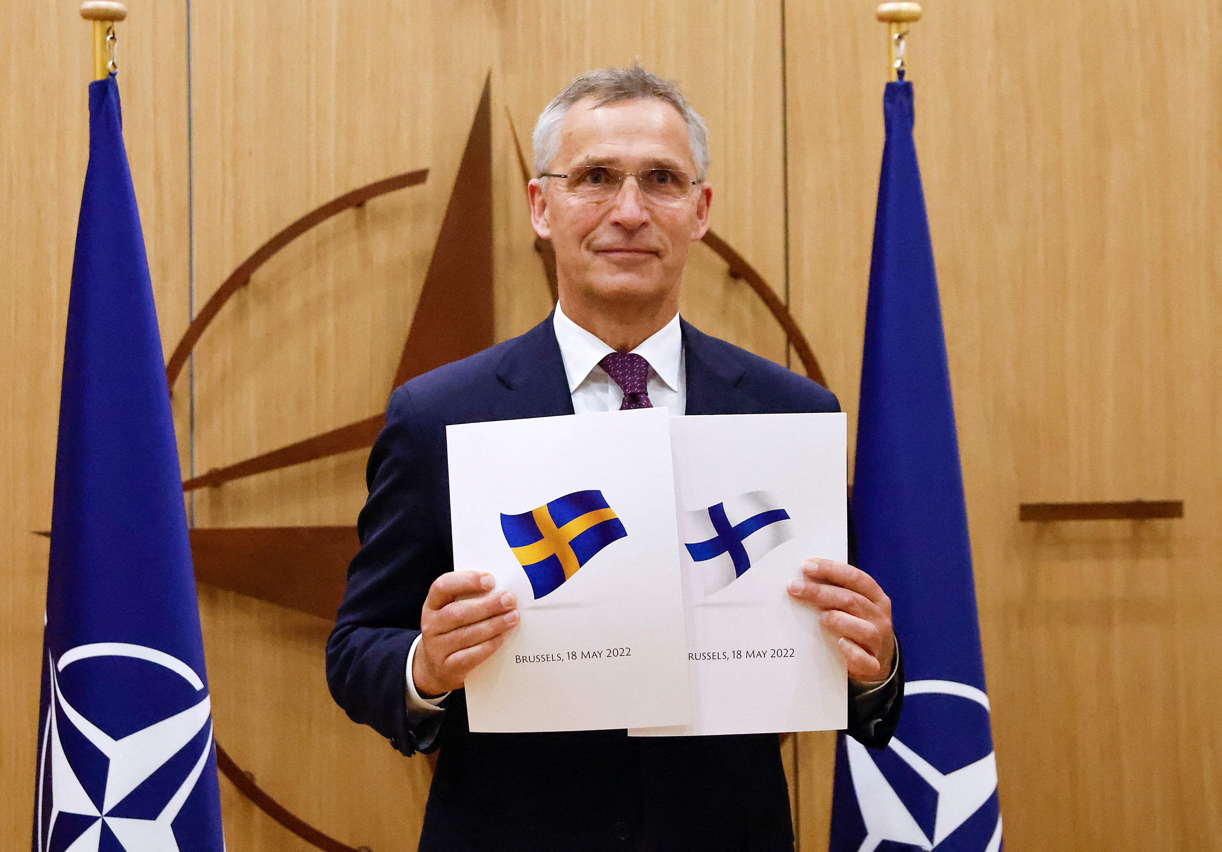 TOPSHOT - NATO Secretary-General Jens Stoltenberg poses with application documents presented by Finland's Ambassador to NATO Klaus Korhonen and Sweden's Ambassador to NATO Axel Wernhoff during a ceremony to mark Sweden's and Finland's application for membership in Brussels, on May 18, 2022. - Finland and Sweden submitted their applications for NATO membership on May 18, 2022 and consultations were underway between the Allies to lift Turkey's opposition to the integration of the two Nordic countries into the Alliance. (Photo by JOHANNA GERON / POOL / AFP)