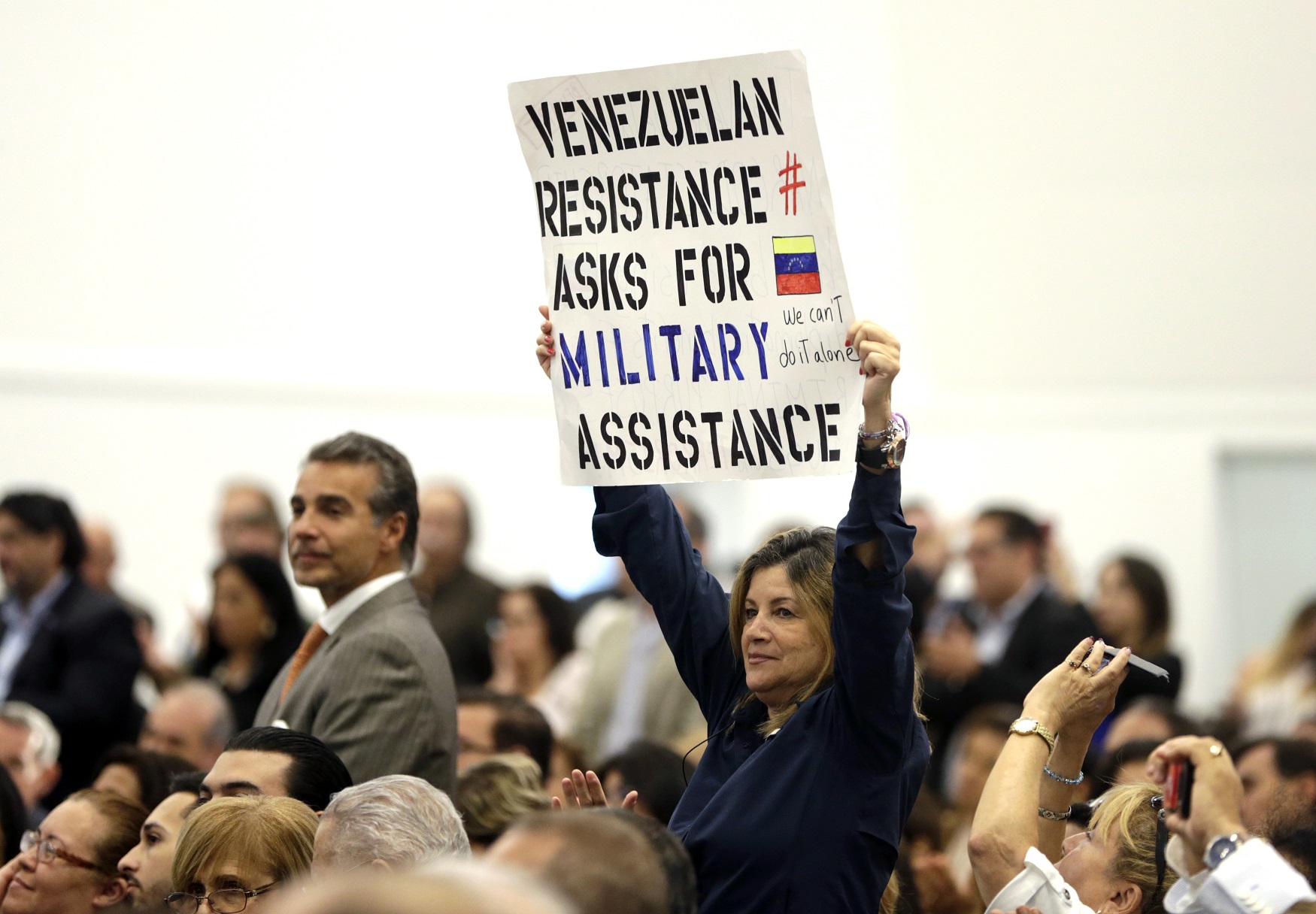 Una exiliada venezolana mostró el miércoles 23 de agosto una pancarta en la que pide ayuda militar de Estados Unidos para enfrentar al gobierno de Nicolás Maduro. Lo hizo durante la visita del vicepresidente Mike Pence a la ciudad de Doral, Florida.