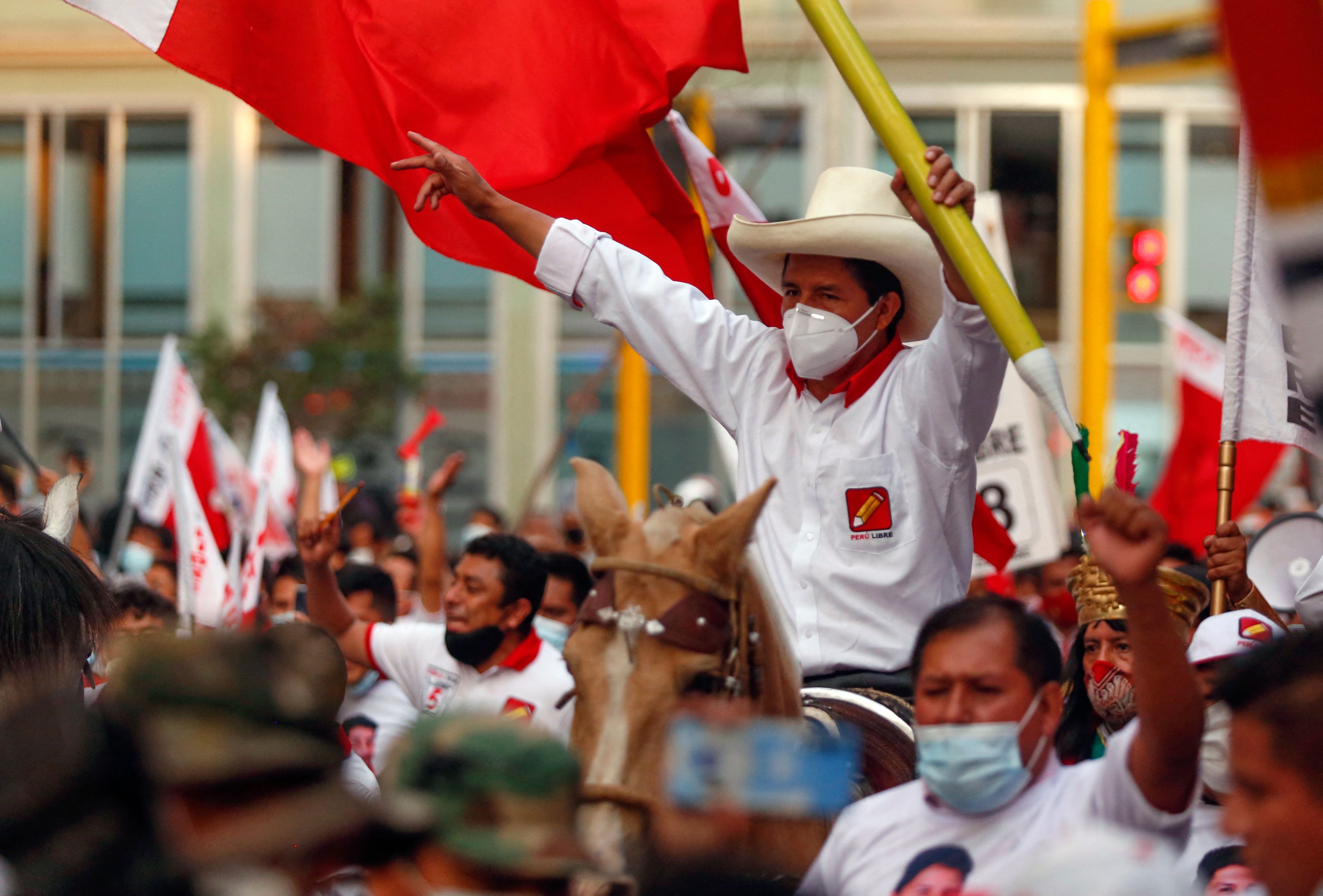 Peruvian presidential candidate for the radical leftist party Peru Libre (Free Peru), Pedro Castillo, rides a horse holding a giant pencil during the closing rally of his campaign in Lima on April 8, 2021. - Castillo 51-year-old school teacher native of Cajamarca, aspires to surprise the elections in Peru, after leaving anonymity in 2017 by leading a long strike by the teachers. He gained prominence with options to move on to the decisive second round, during the electoral debates, according to the polls. (Photo by Gian MASKO / AFP)