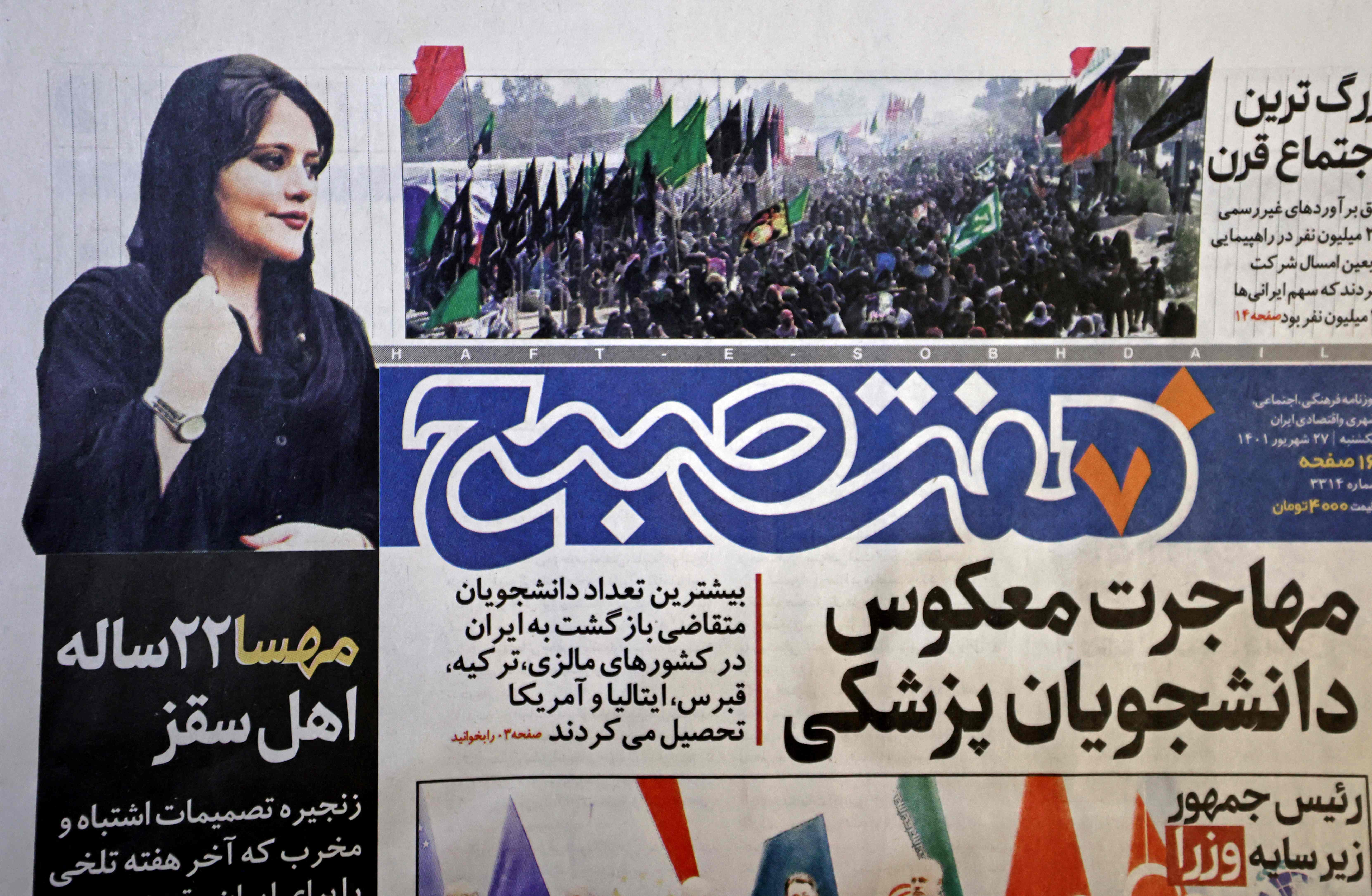 A picture taking in Tehran on September 18, 2022 shows the front page of the Iranian newspaper Hafteh Sobh featuring a photograph of Mahsa Amini, a woman who died after being arrested by the Islamic republic's "morality police" two days ago. - Amini, 22, was on a visit with her family to the Iranian capital when she was detained on September 13 by the police unit responsible for enforcing Iran's strict dress code for women, including the wearing of the headscarf in public. She was declared dead on September 16 by state television after having spent three days in a coma. (Photo by ATTA KENARE / AFP)