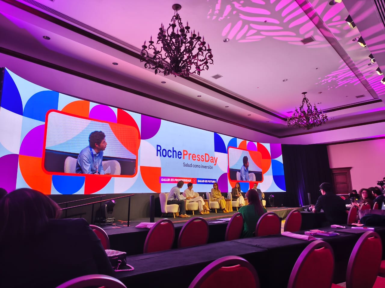 Cuatro personas sentadas en un panel hablando.