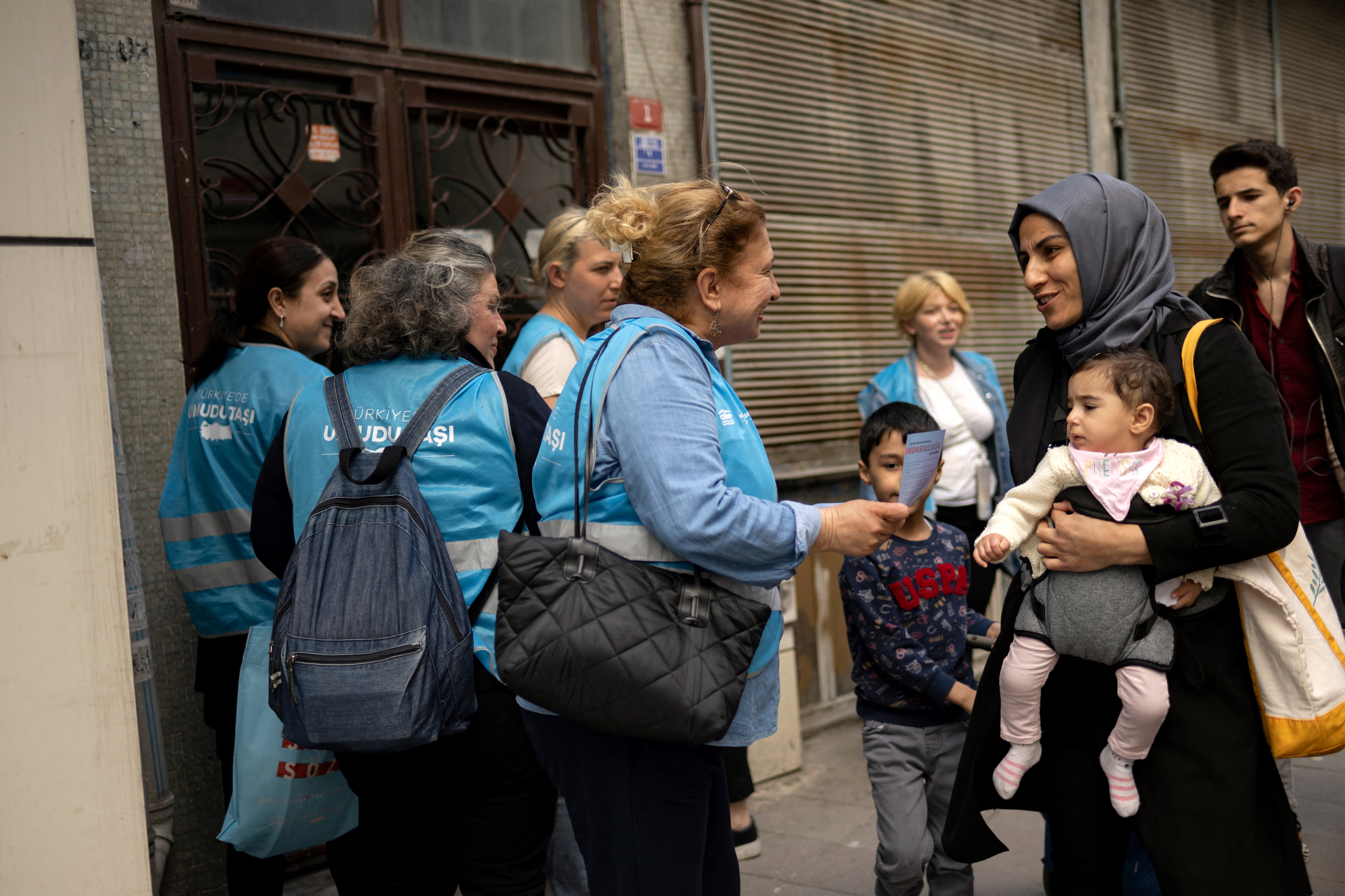 Supporters of Turkey's opposition presidential candidate Kemal Kilicdaroglu distribute leaflets as they walk on the streets to persuade people to vote for him, in Istanbul on May 23, 2023. With Erdogan hot favourite, the opposition is searching for votes to push secular leader Kemal Kilicdaroglu over the line in presidential runoff due on May 28, 2023 and they will have to win over women, particularly working class housewives -- the bedrock of Erdogan's support. (Photo by Yasin AKGUL / AFP)