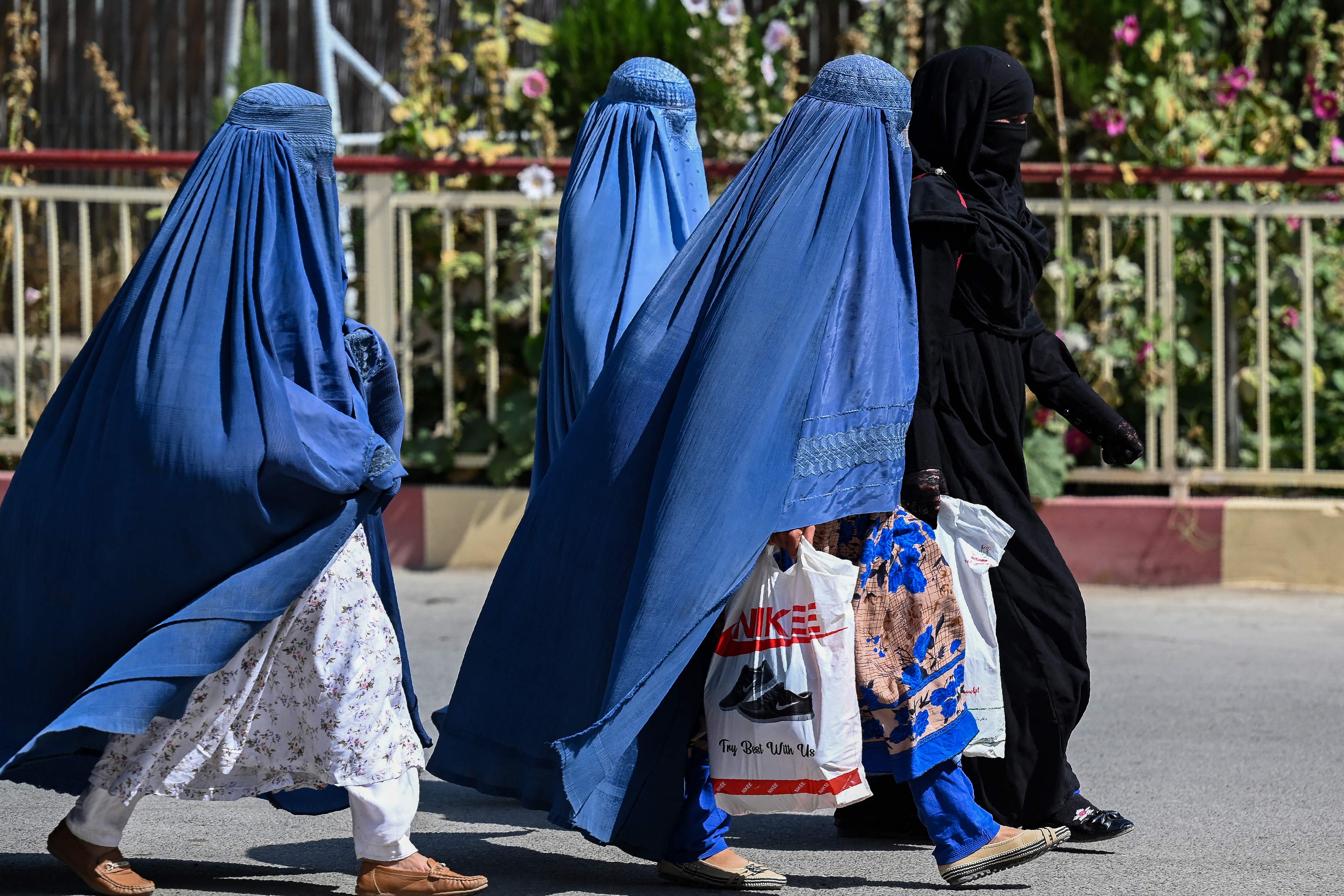 Burqa clad Afghan women walk near the premises of Wazir Akbar Khan hospital in Kabul on September 1, 2021. (Photo by Aamir QURESHI / AFP)