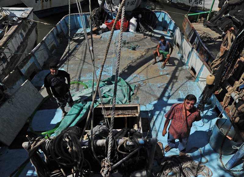 Francisco Javier Reyes (izquierda), Renzo Vásquez y Minor Bonilla a bordo del barco Capitán Bonilla, primera embarcación camaronera a la que se le venció el permiso de pesca de arrastre para la captura de camarón. Bonilla, dueño del barco, manifestó que en esta transición el apoyo estatal ha sido nulo, aunque unas 45 personas se ven afectadas directa e indirectamente. | ALBERT MARÍN.