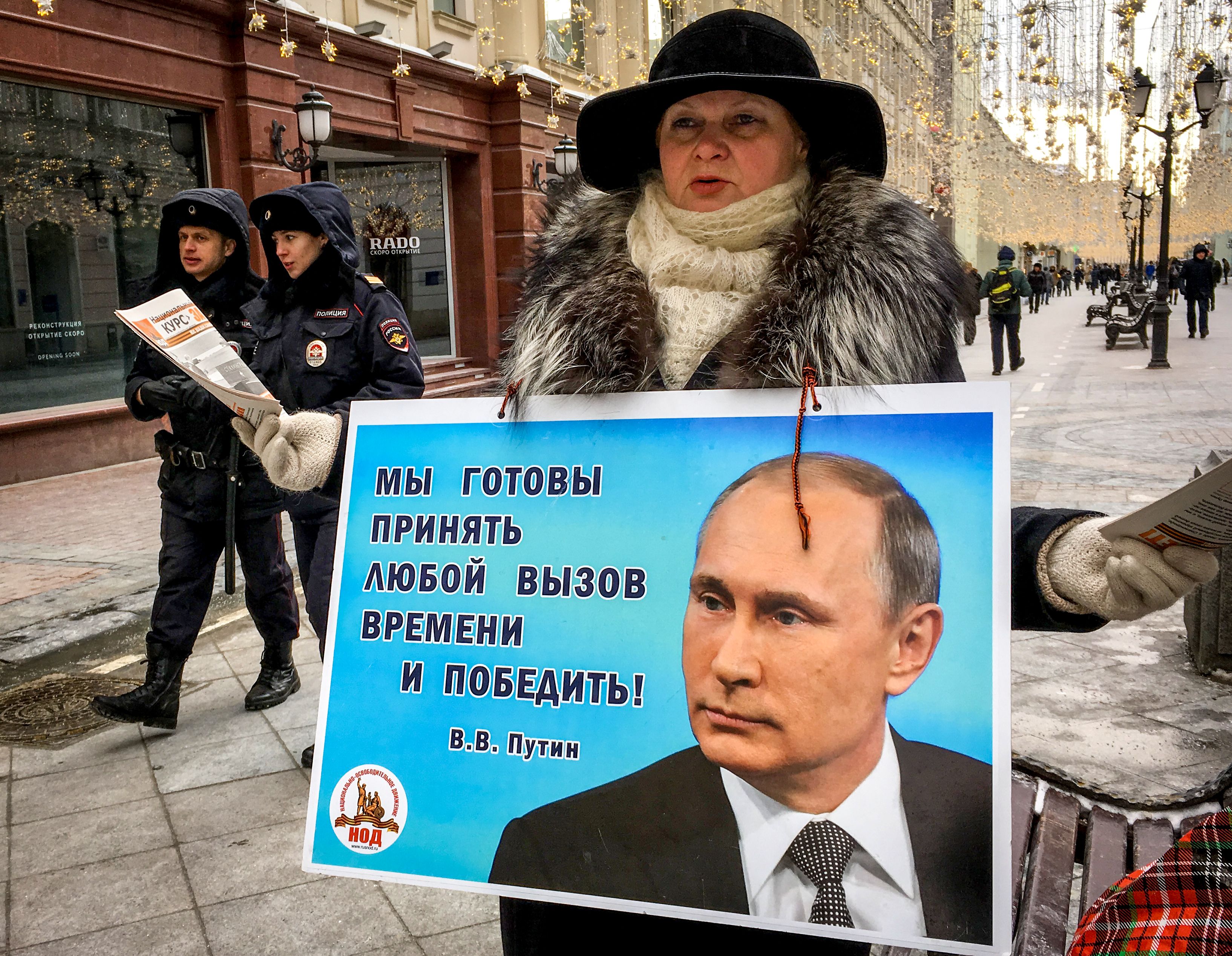 Una activista distribuye panfletos electorales en apoyo del candidato presidencial, el presidente Vladimir Putin, en una calle del centro de Moscú el 16 de marzo de 2018. Rusia votará por presidente el 18 de marzo.