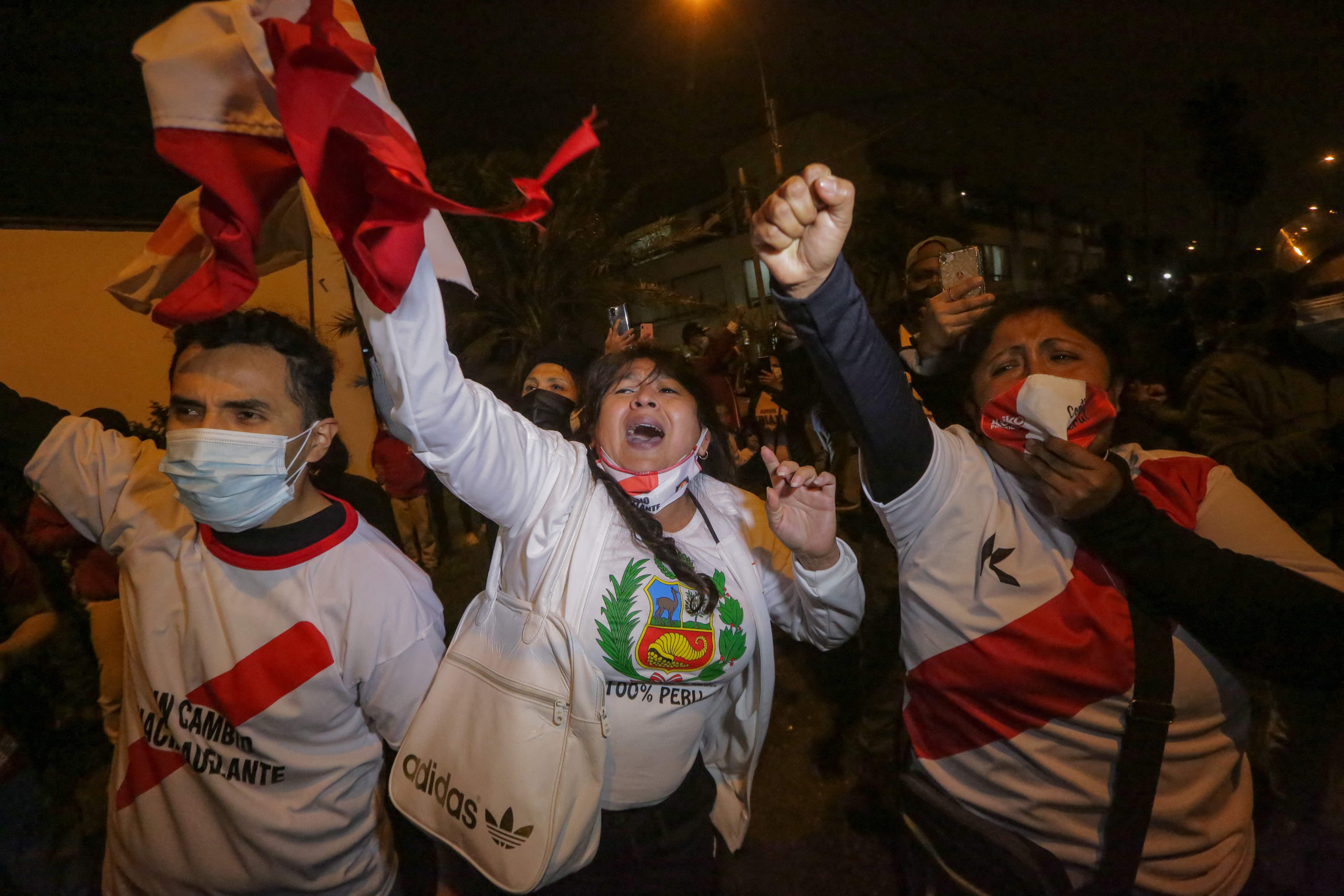 Supporters of the Peruvian presidential candidate, right-wing Keiko Fujimori, celebrate outside the Fuerza Popular party headquarters after the closure of the polling stations in Lima, on June 6, 2021. - The right-wing candidate Keiko Fujimori obtained 50.3% of the votes on Sunday compared to 49.7% of her leftist rival Pedro Castillo, according to an exit poll by the Ipsos firm released at the closing of the polling stations in Peru. (Photo by Luka GONZALES / AFP)