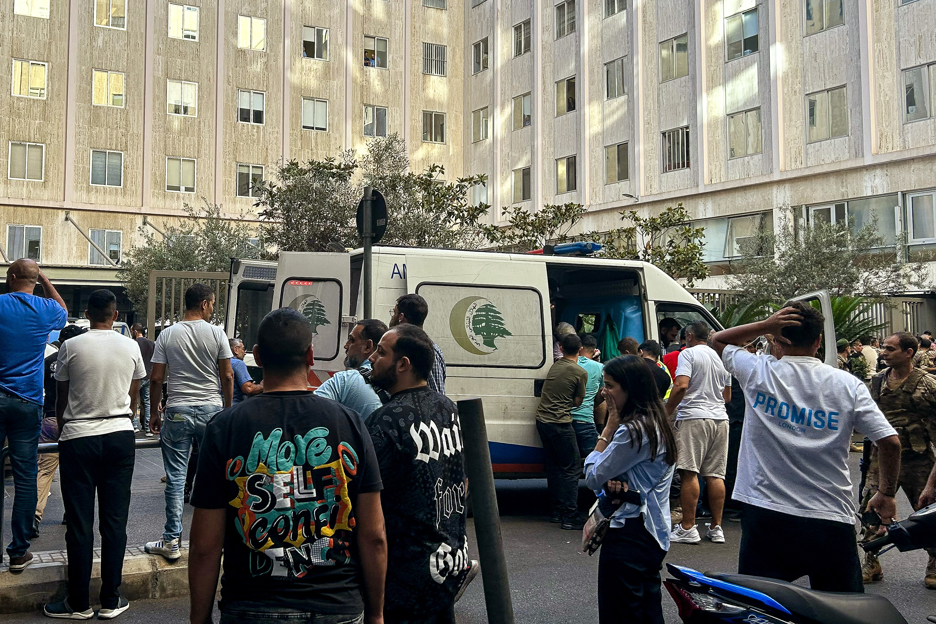 La gente reacciona cerca de una ambulancia mientras los heridos son trasladados a un hospital en Beirut, después de que se produjeran explosiones en varios bastiones de Hezbolá en todo el Líbano