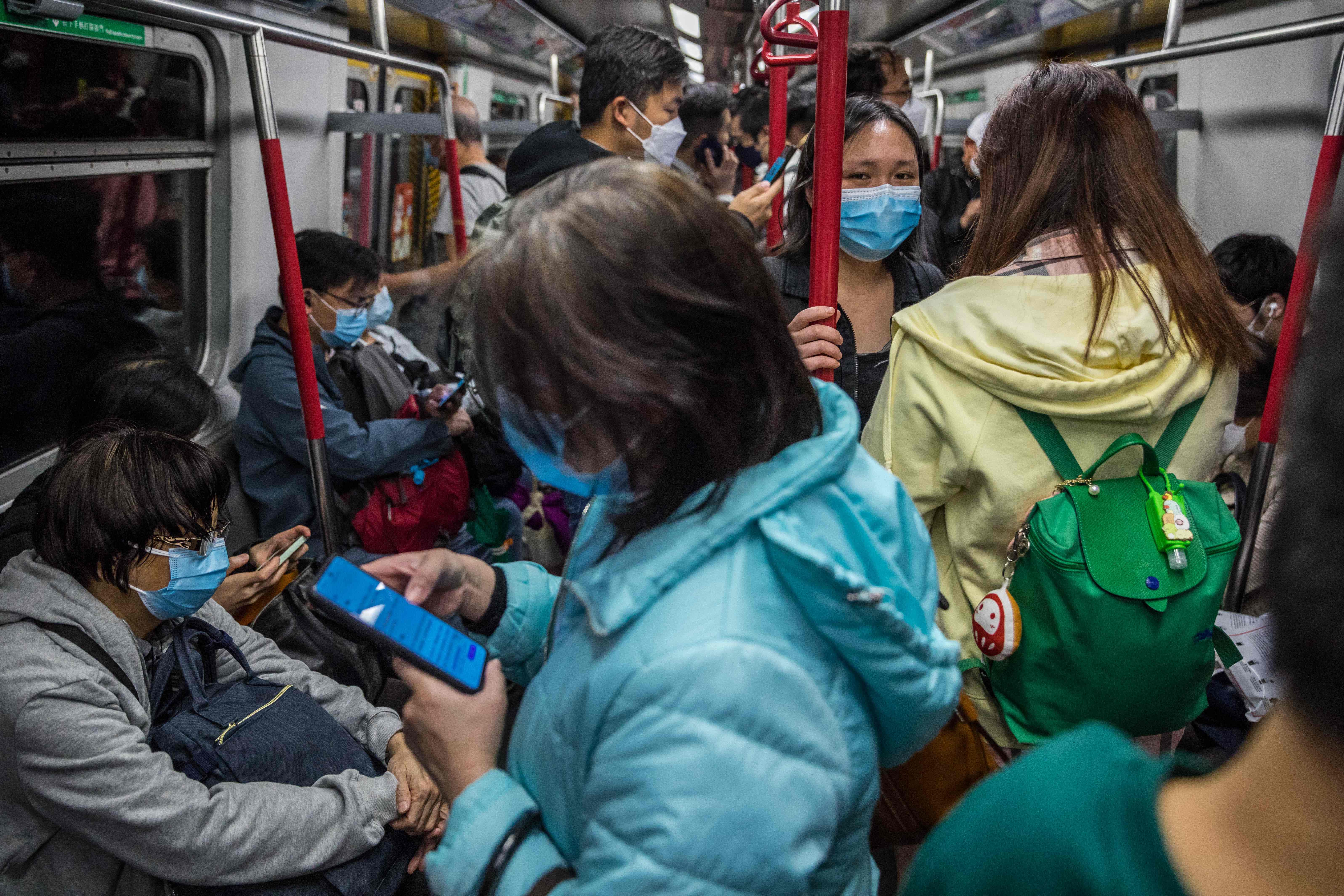 People wearing face masks commute on a train in Hong Kong on March 7, 2022, amid the city's worst-ever Covid-19 coronavirus outbreak. (Photo by DALE DE LA REY / AFP)