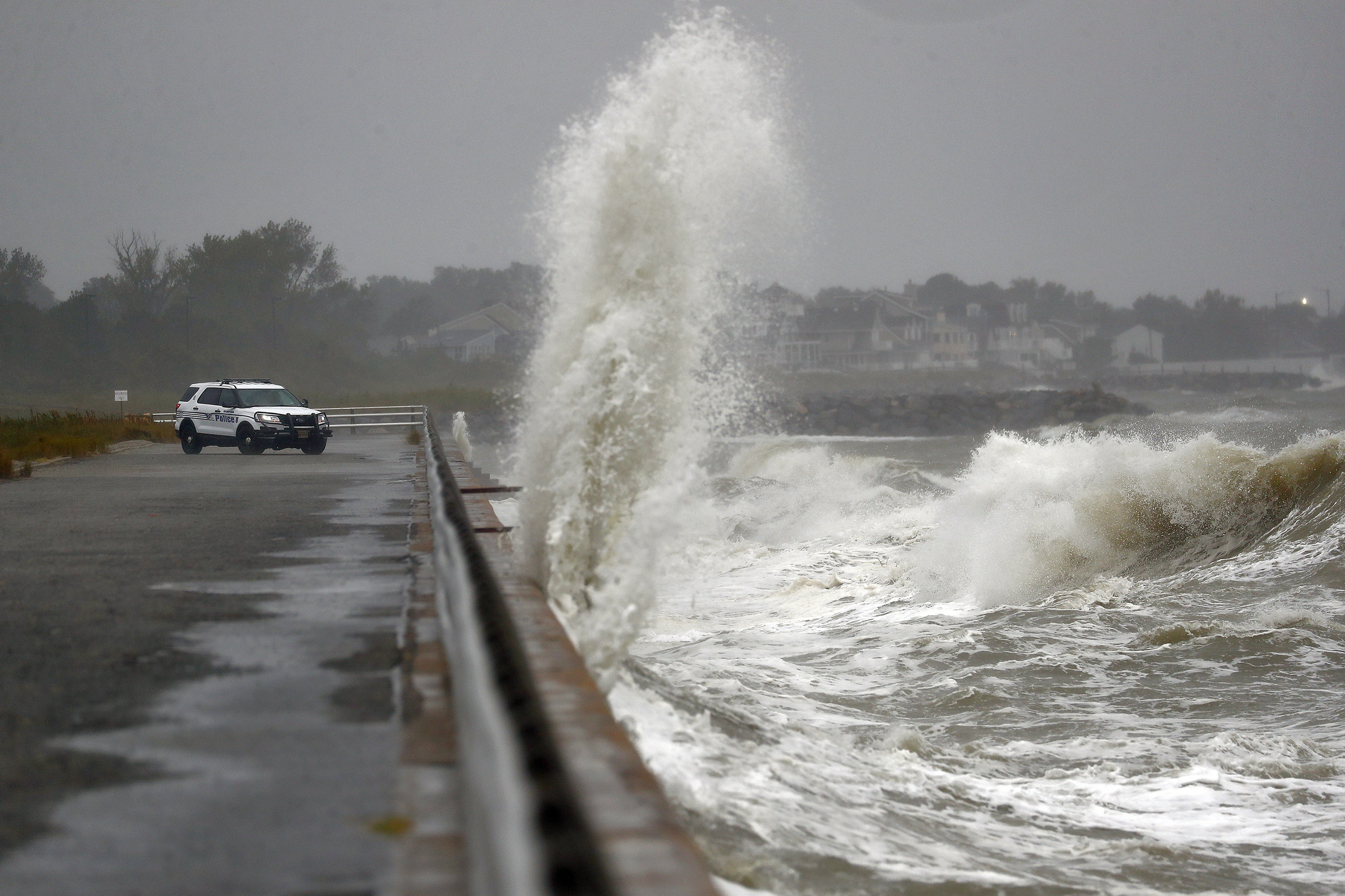Waves crash ashore near a Hampton police officer's vehicle at Fort Monroe, Va., Friday Sept. 6, 2019. More than 350,000 people were without electricity in the Carolinas and Virginia as Hurricane Dorian moved up the coast. (Jonathon Gruenke/The Virginian-Pilot via AP)